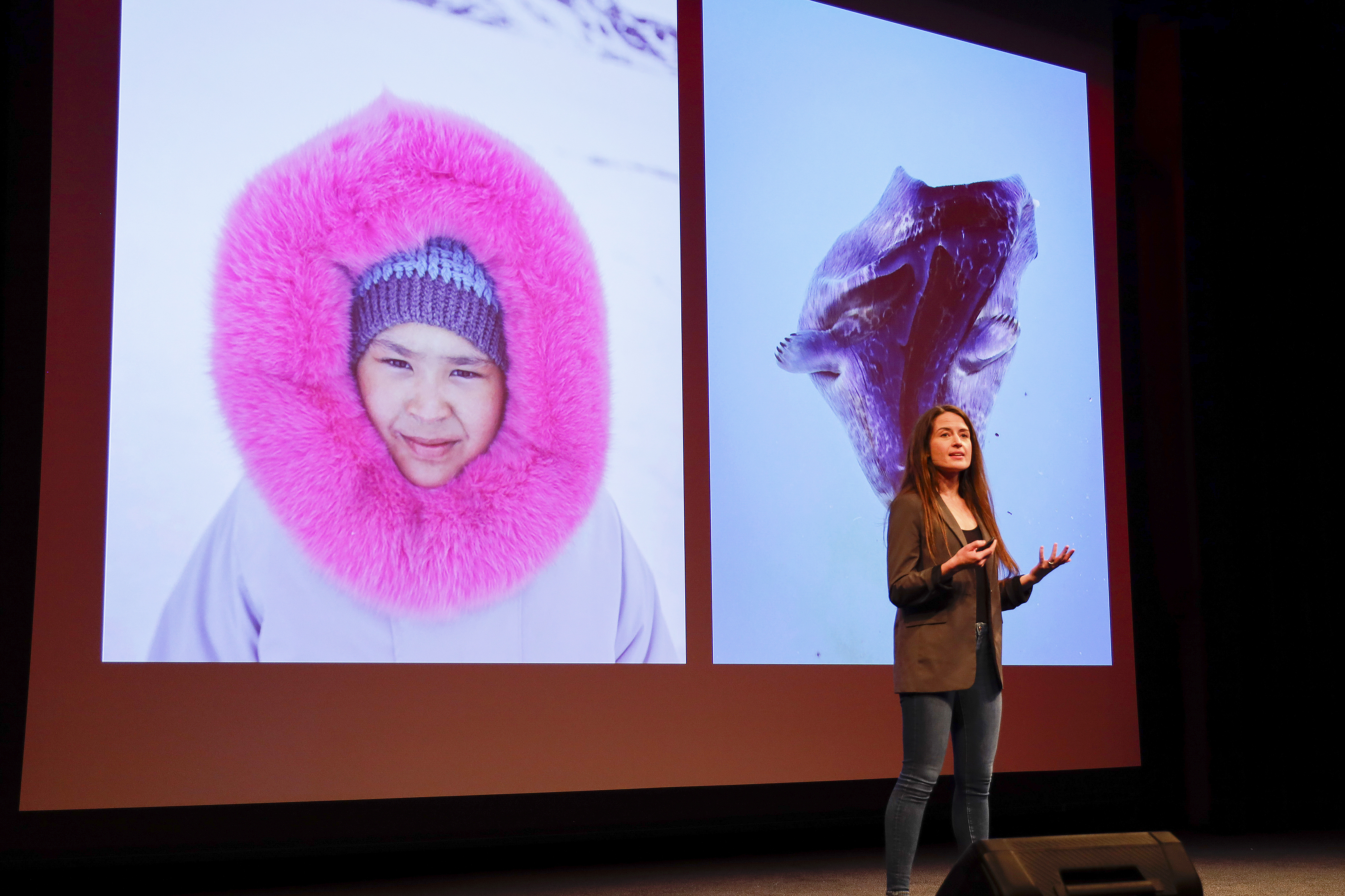 alum Acacia Johnson on stage with photos of Arctic behind her