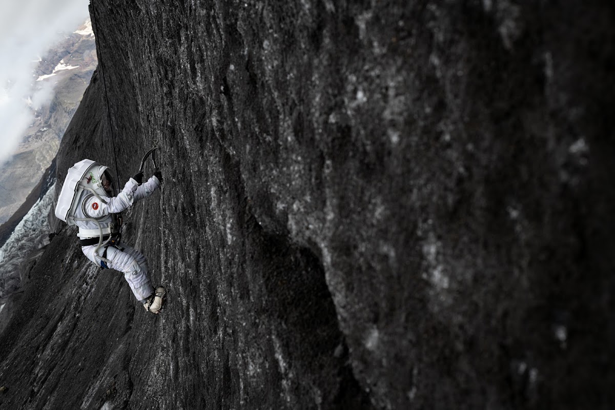 Researcher climbs rock face in spacesuit