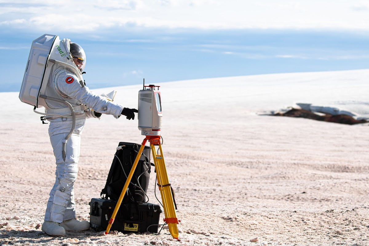 Researcher in spacesuit works with scientific equipment
