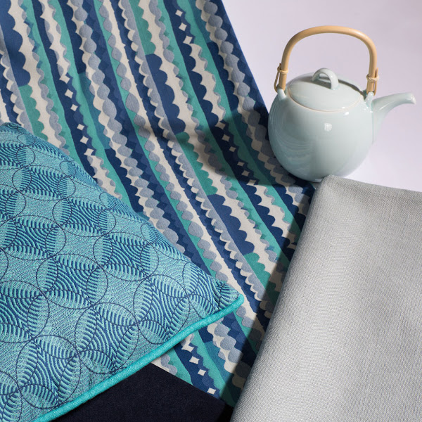 Blue textiles sitting next to a teapot