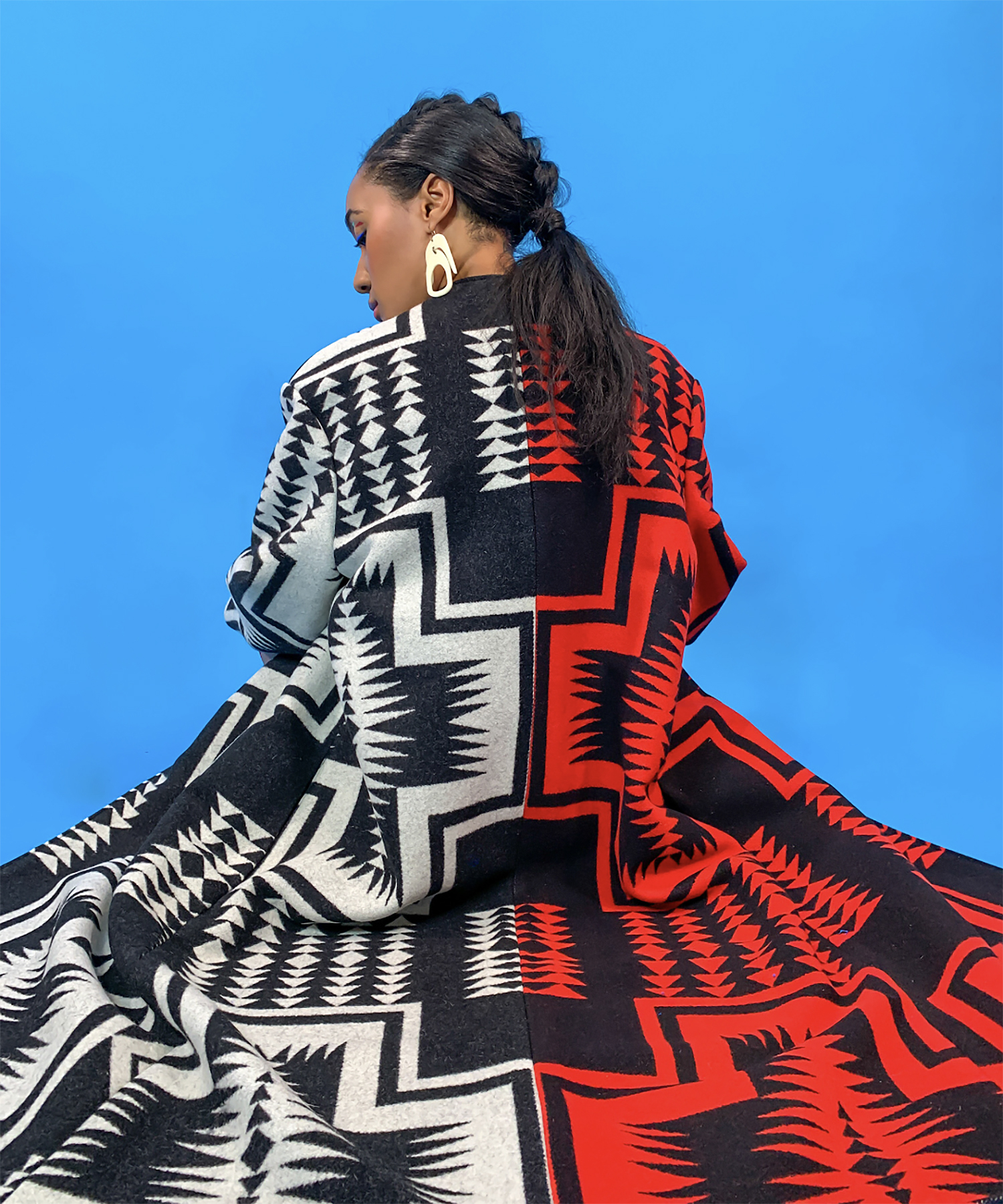 woman modeling a gorgeous black and red Navajo-inspired coat by Emmerich