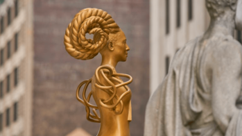 Golden statue of a female figure with horns on the courthouse in New York.