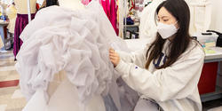 a student pins a length of organza in place