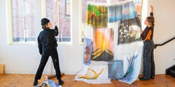 Students hang painted fabric in an illustration studio