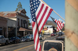 image of an American flag hanging in a small western town