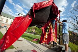 Students setting up large gateway made of red tarp