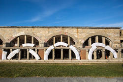 Student work by Maddy Riorda BFA 2017. Installations of broken arches are placed against the outer wall of a building with similar arches. 