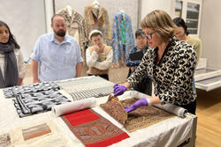 Kate Irvin shows students historical jacquard woven textiles in the RISD Museum archives