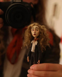 Puppet of a girl with blonde curly hair.