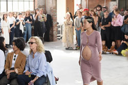 Pregnant model walks in a runway show.