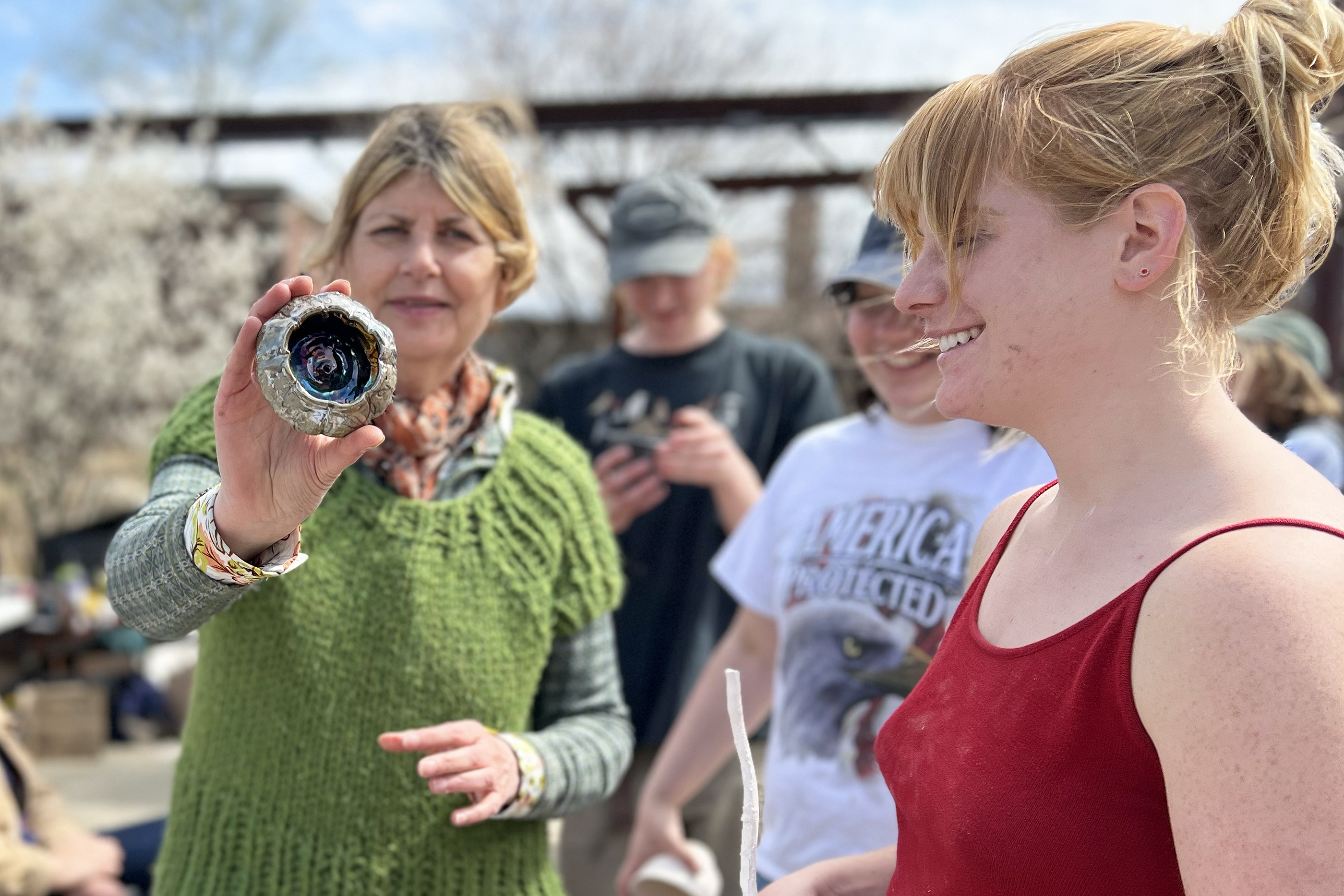 department head Katy Schimert holds up a piece fired in the new raku kiln
