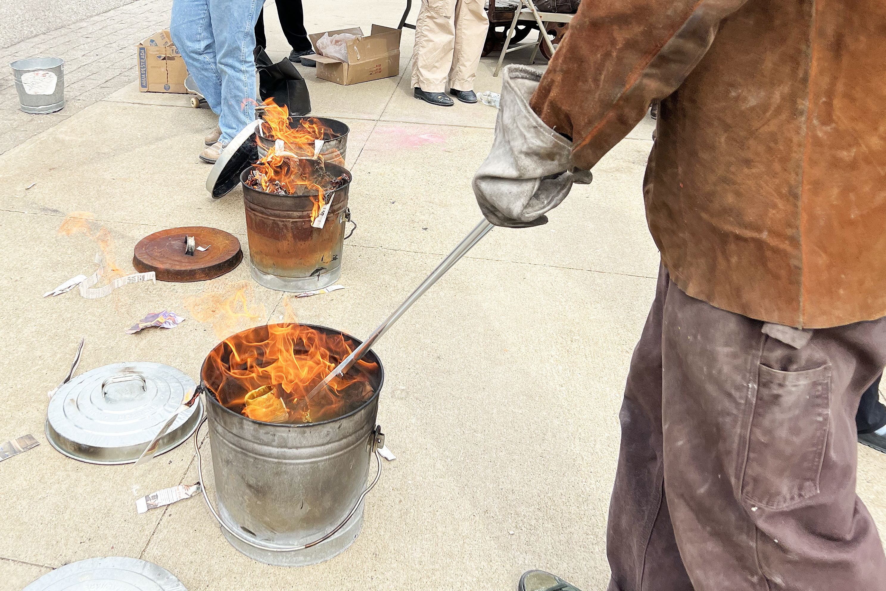 the fired ceramics pieces are moved to a metal bin with burning combustibles