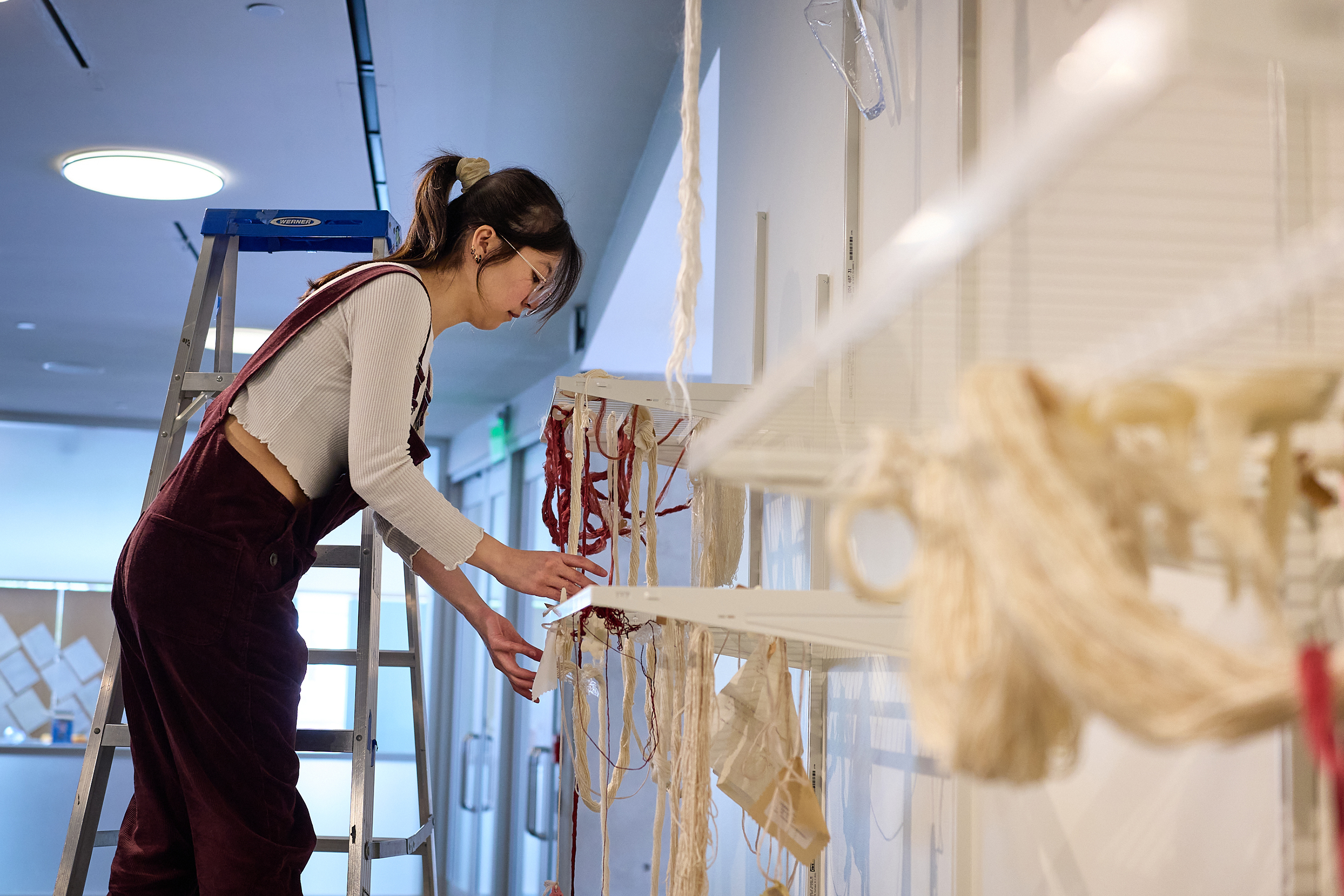 Linda Sok installs her piece in the Chace Center lobby