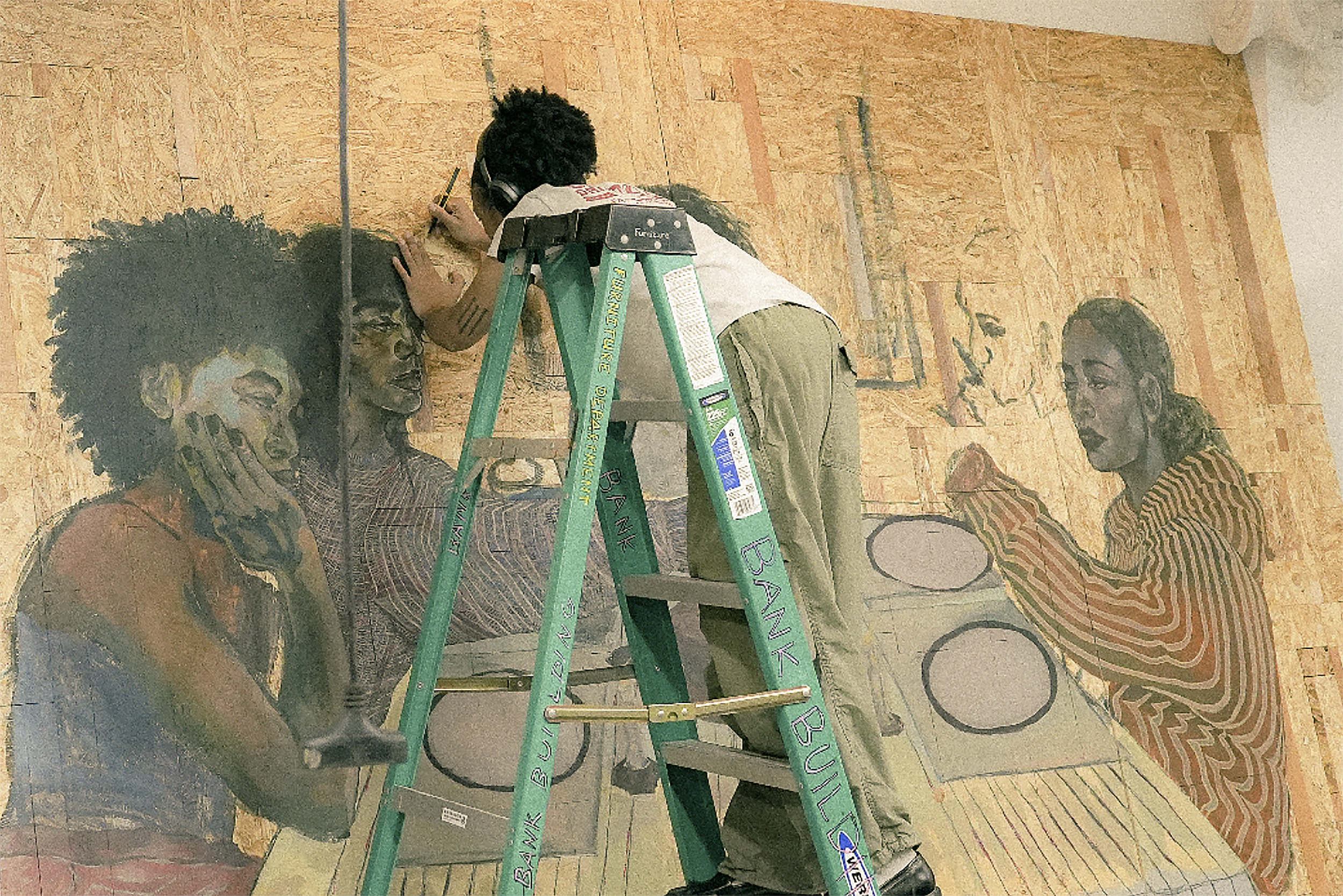the artist uses a ladder to paint the huge piece