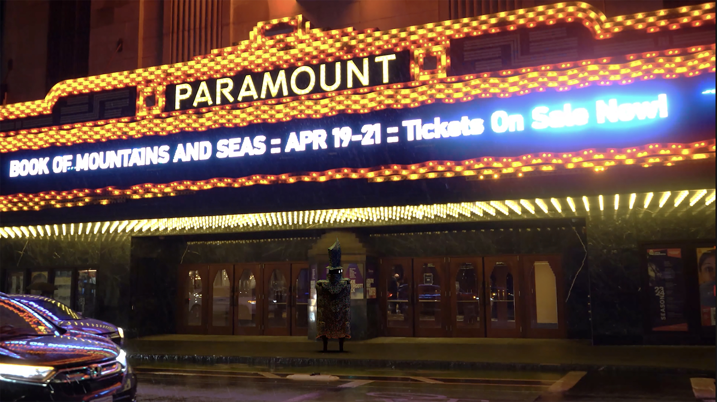 live action still showing a brightly lit theater marquee