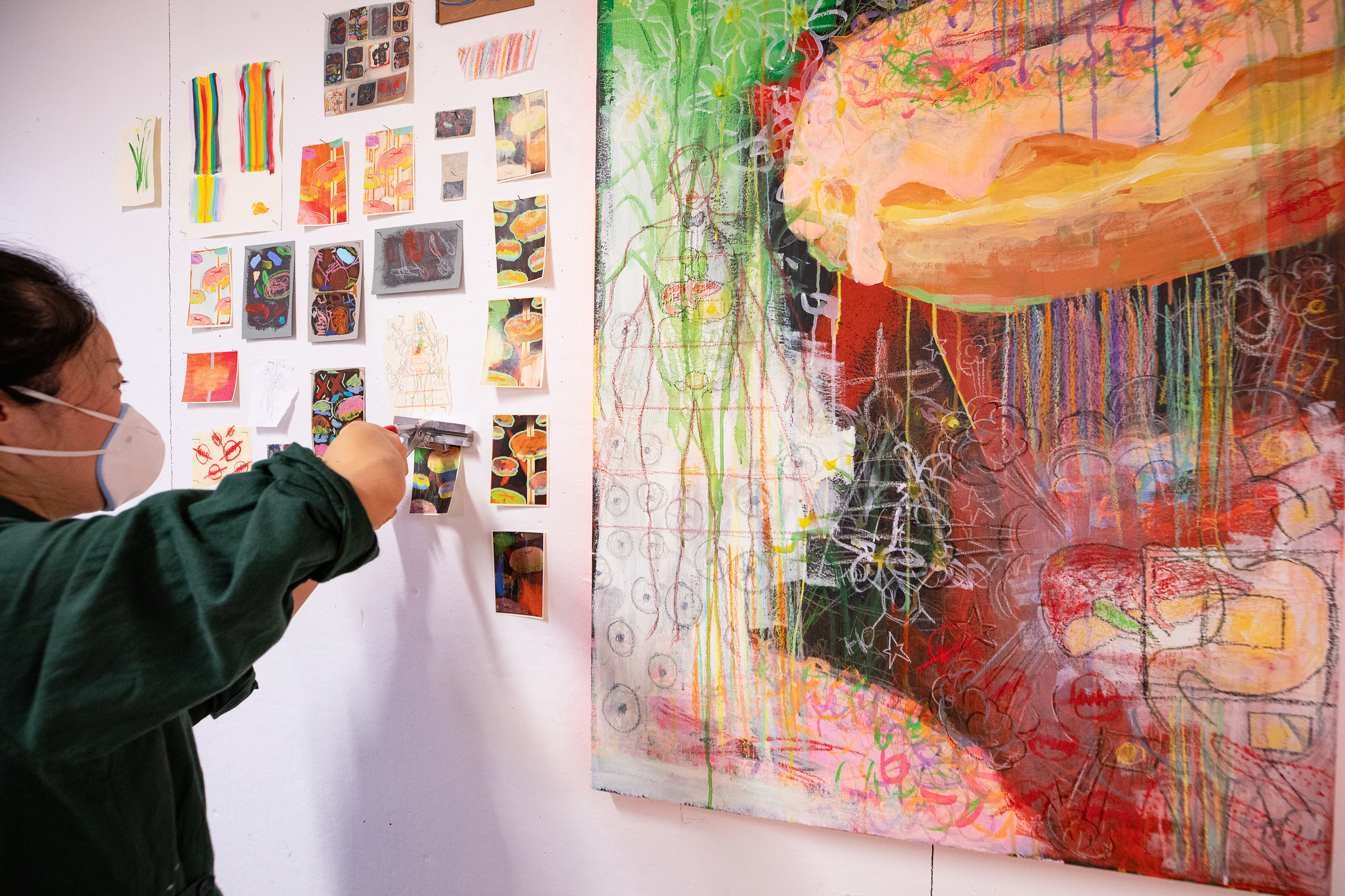 an illustration student pins colorful work to the wall during crits