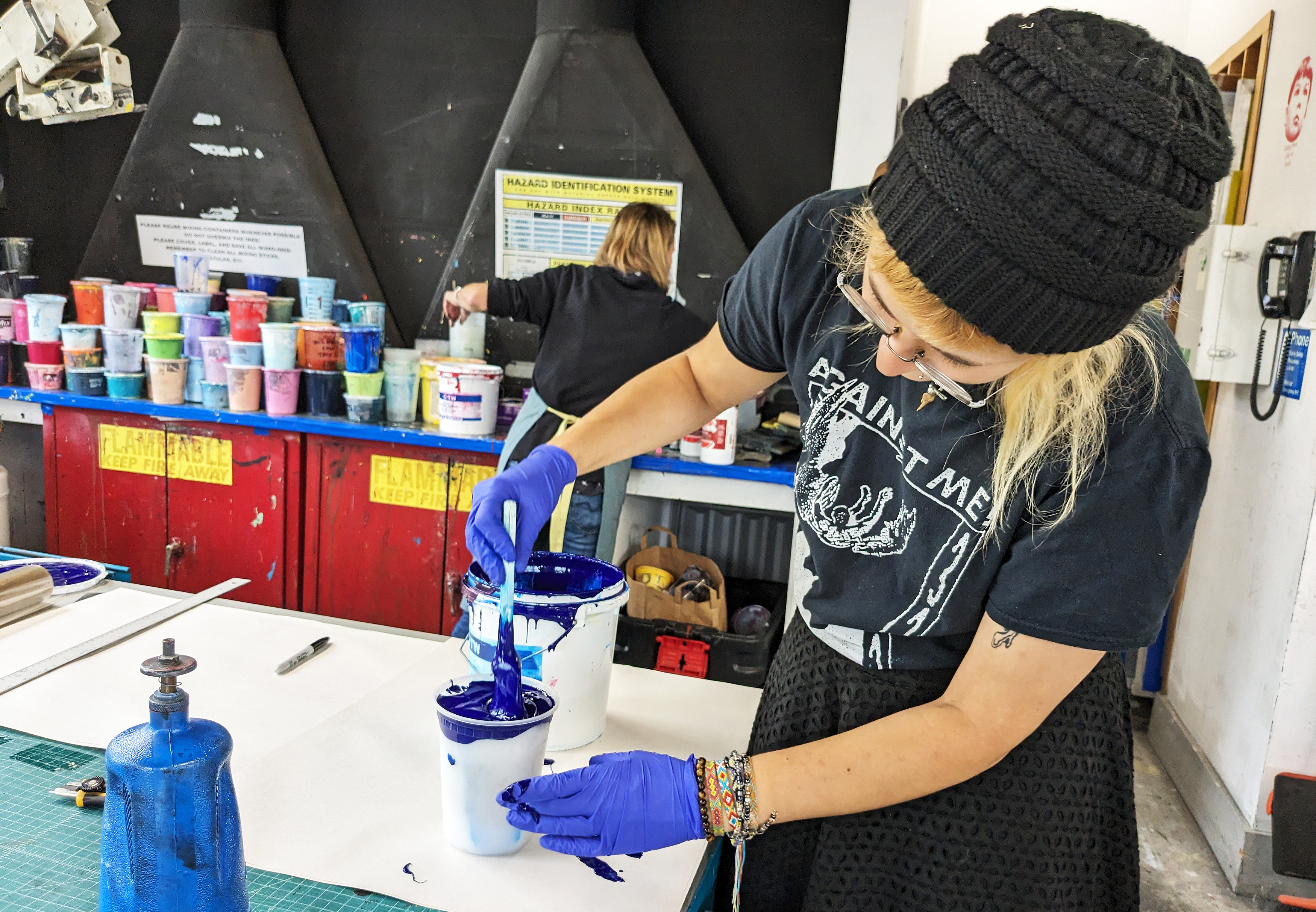Cam Calegari mixes intensely blue ink in the studio