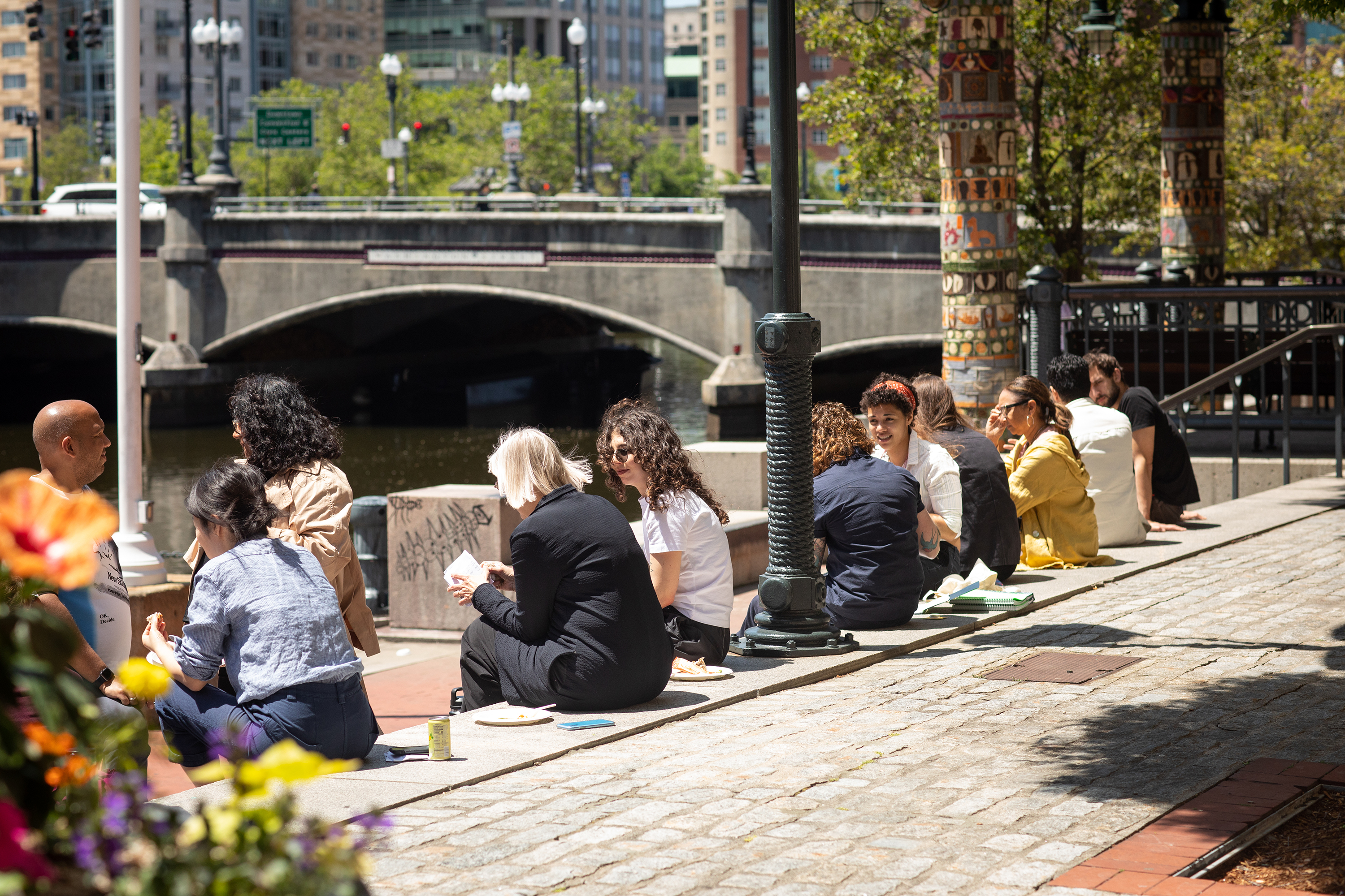 students and faculty chatting on the steps along the canal