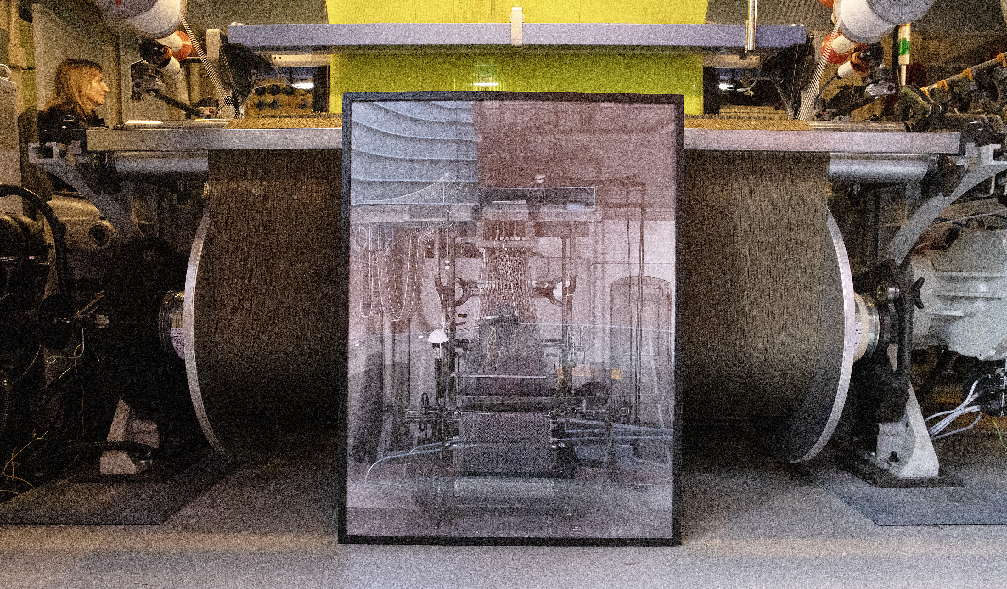a photograph of the old Jacquard loom leans up against the new one