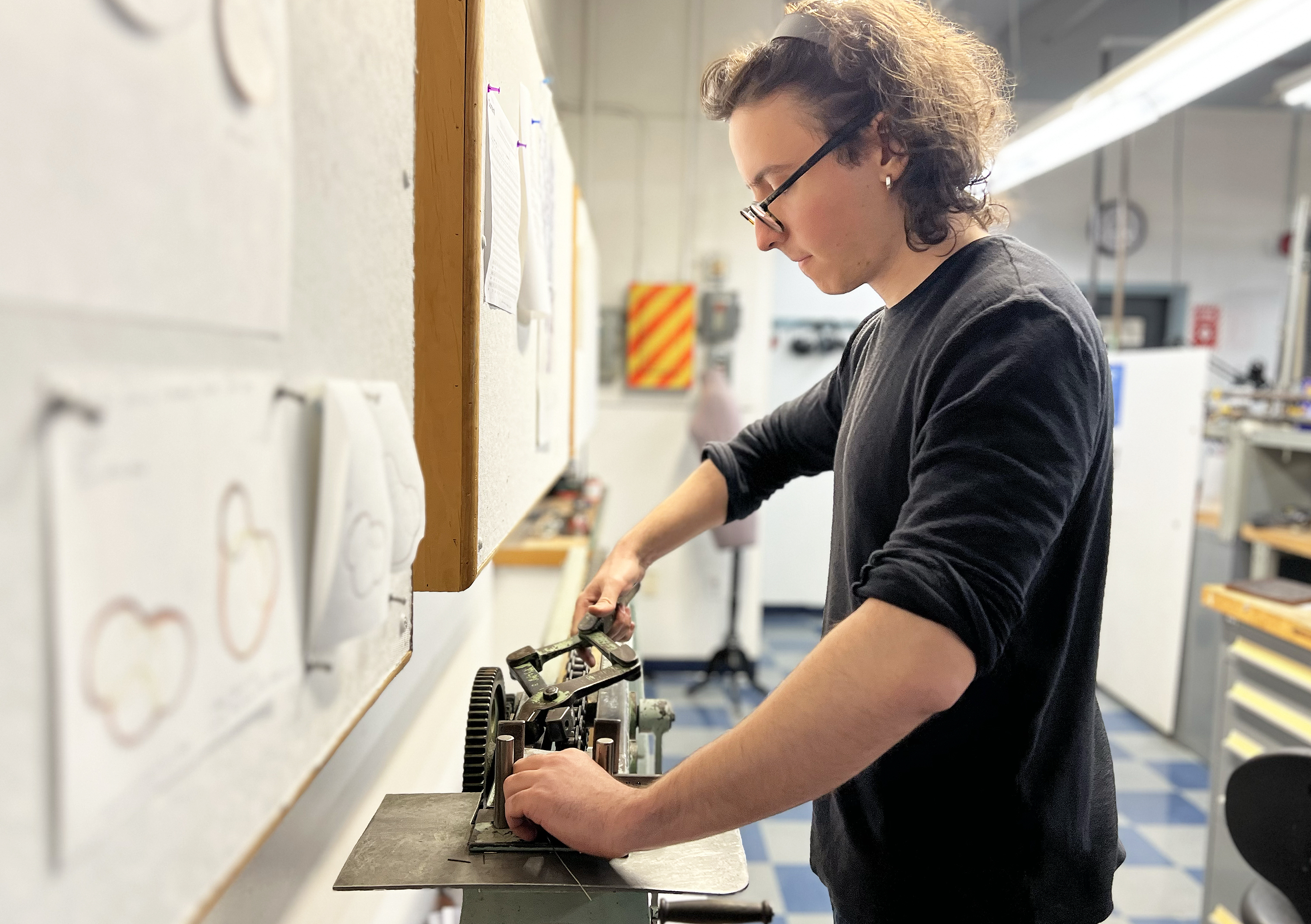 a student draws platinum wire using an industrial machine