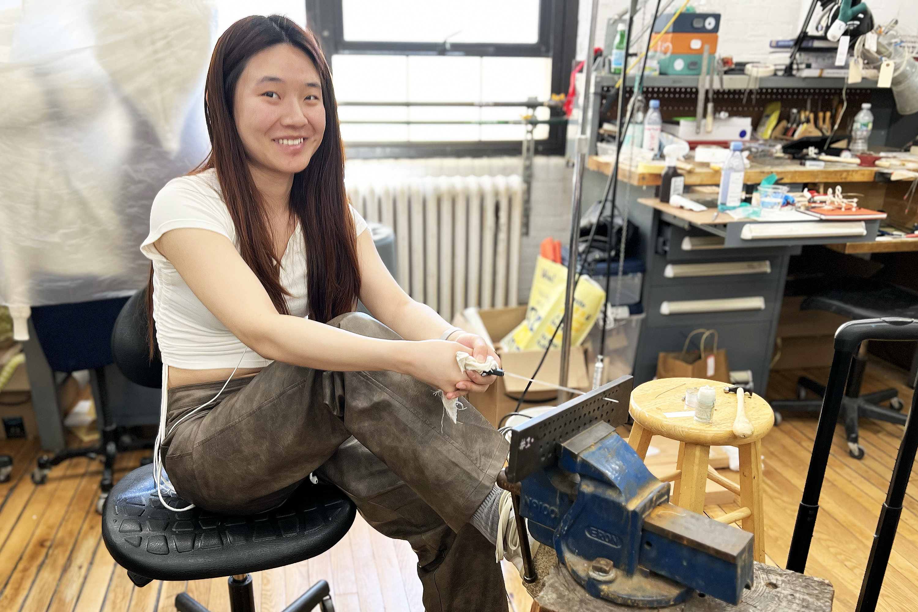 a student uses her whole body to manually draw platinum wire