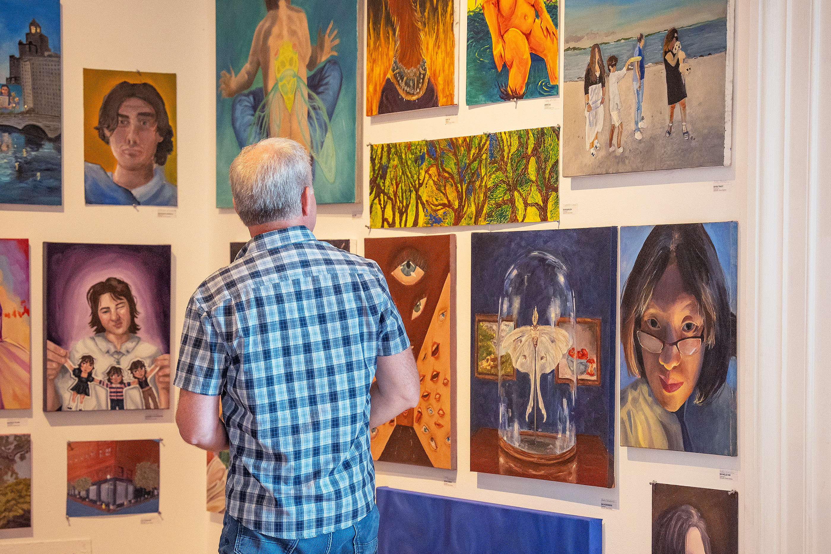 Mark Moscone views paintings by Pre-College students mounted in Woods-Gerry Gallery