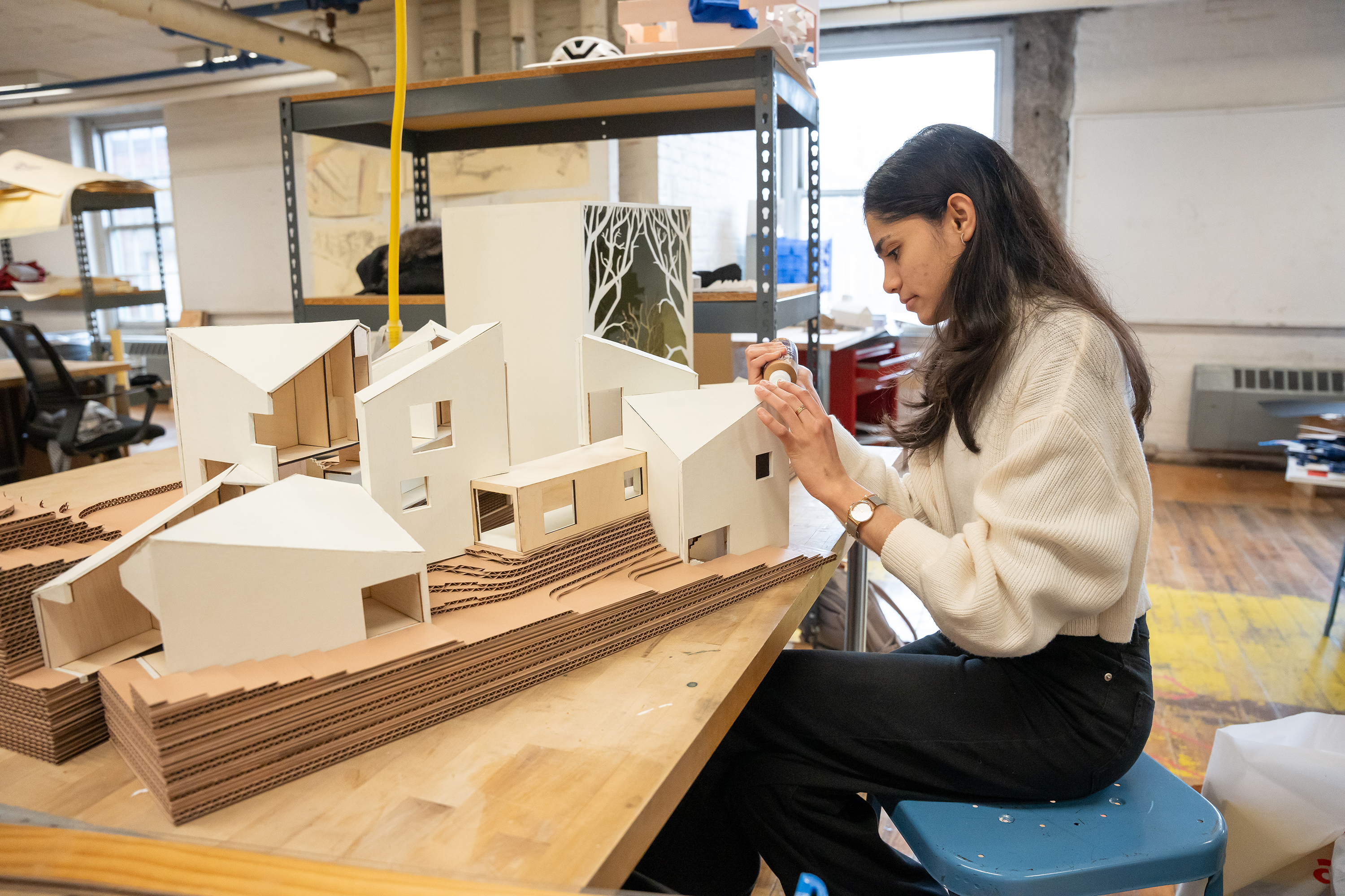 student at work on an architectural model in the studio