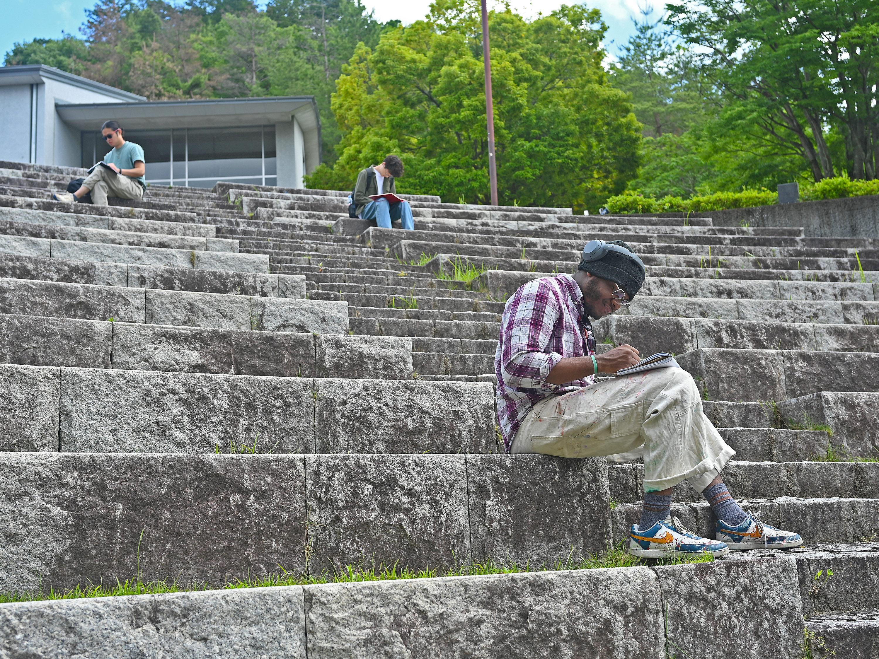 students sketching on the steps of a stone Japanese amphitheater