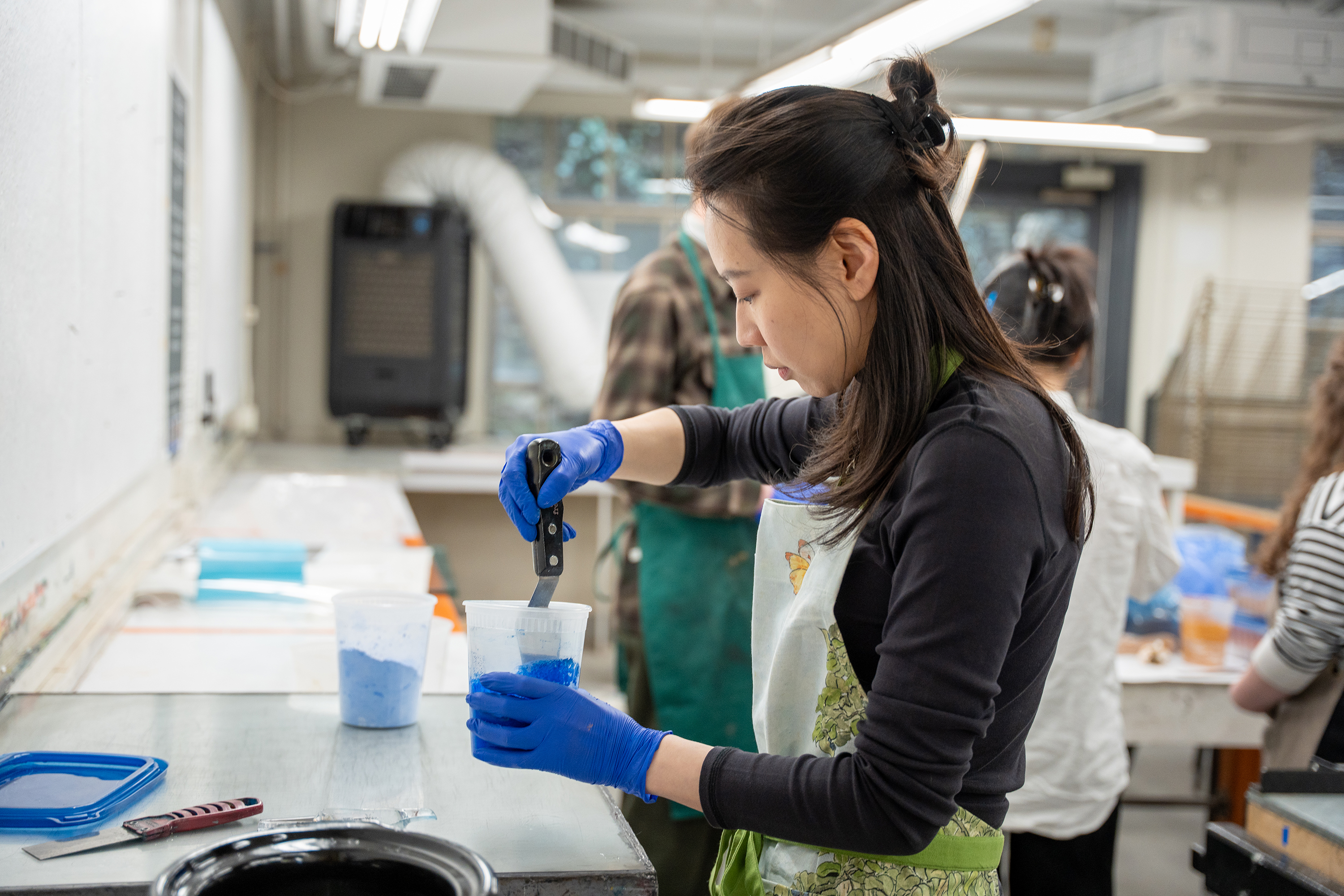 a student mixes Prussian blue paint in Benson Hall