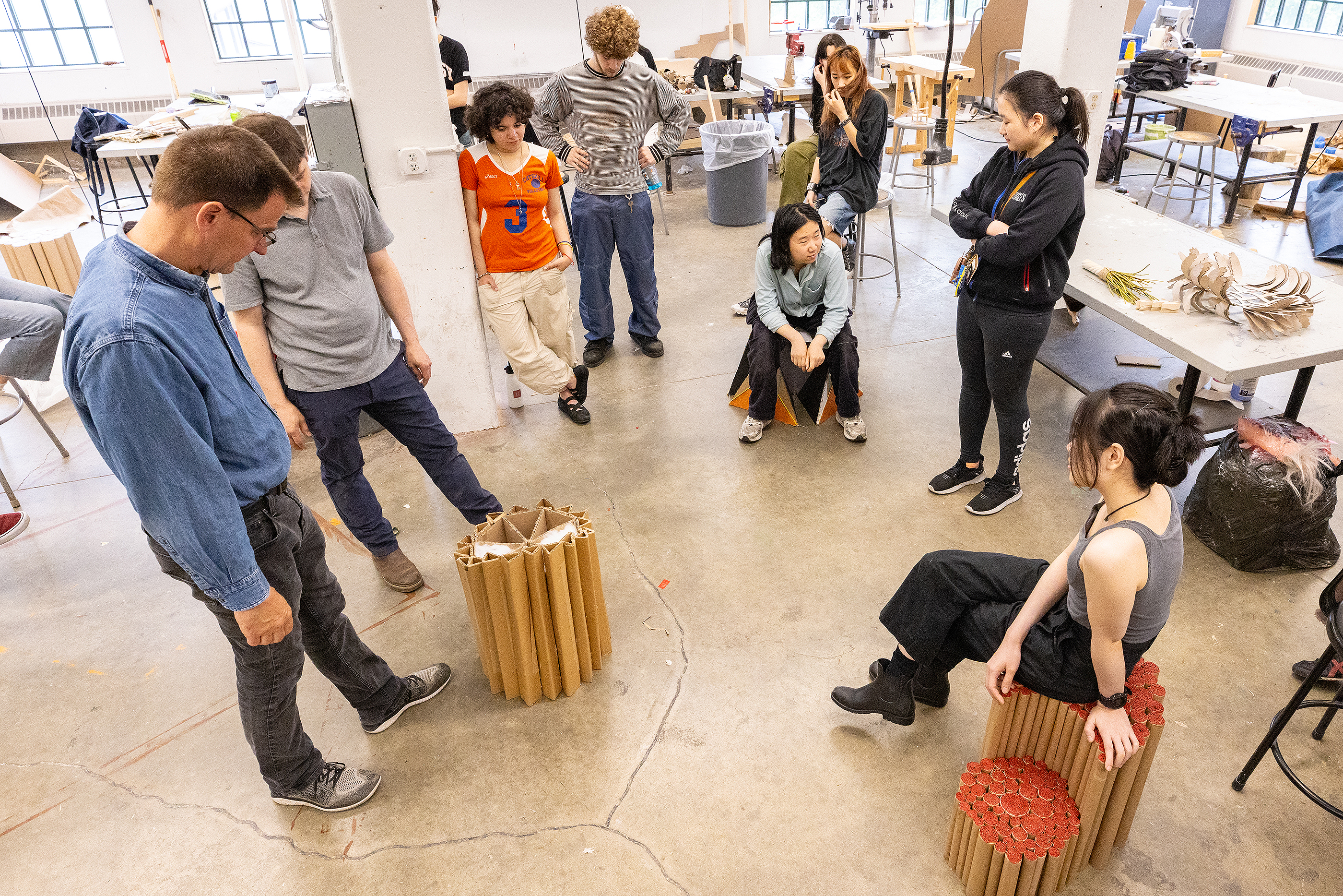 first-year students examine a cardboard stool