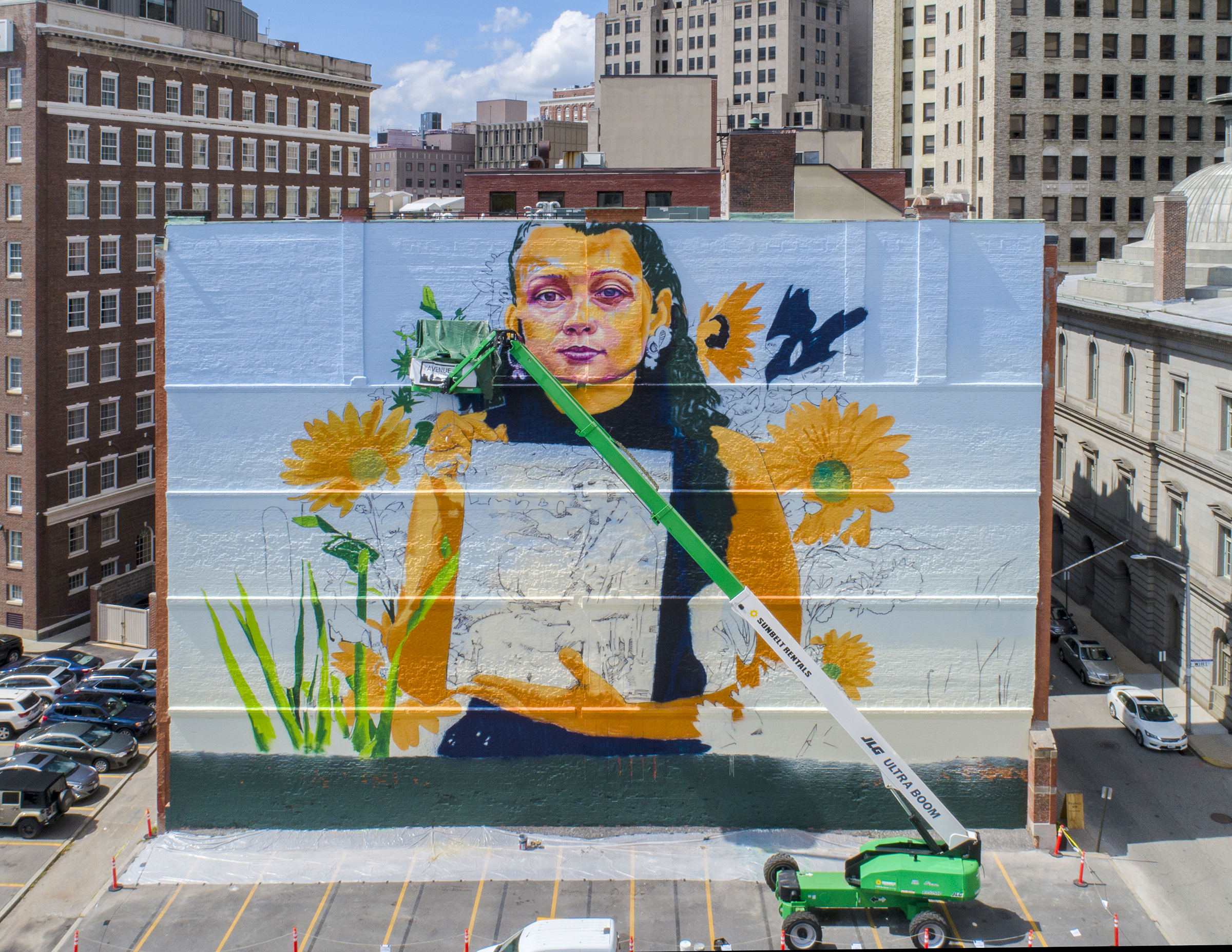 a massive crane parked in front of the unfinished mural in 2018