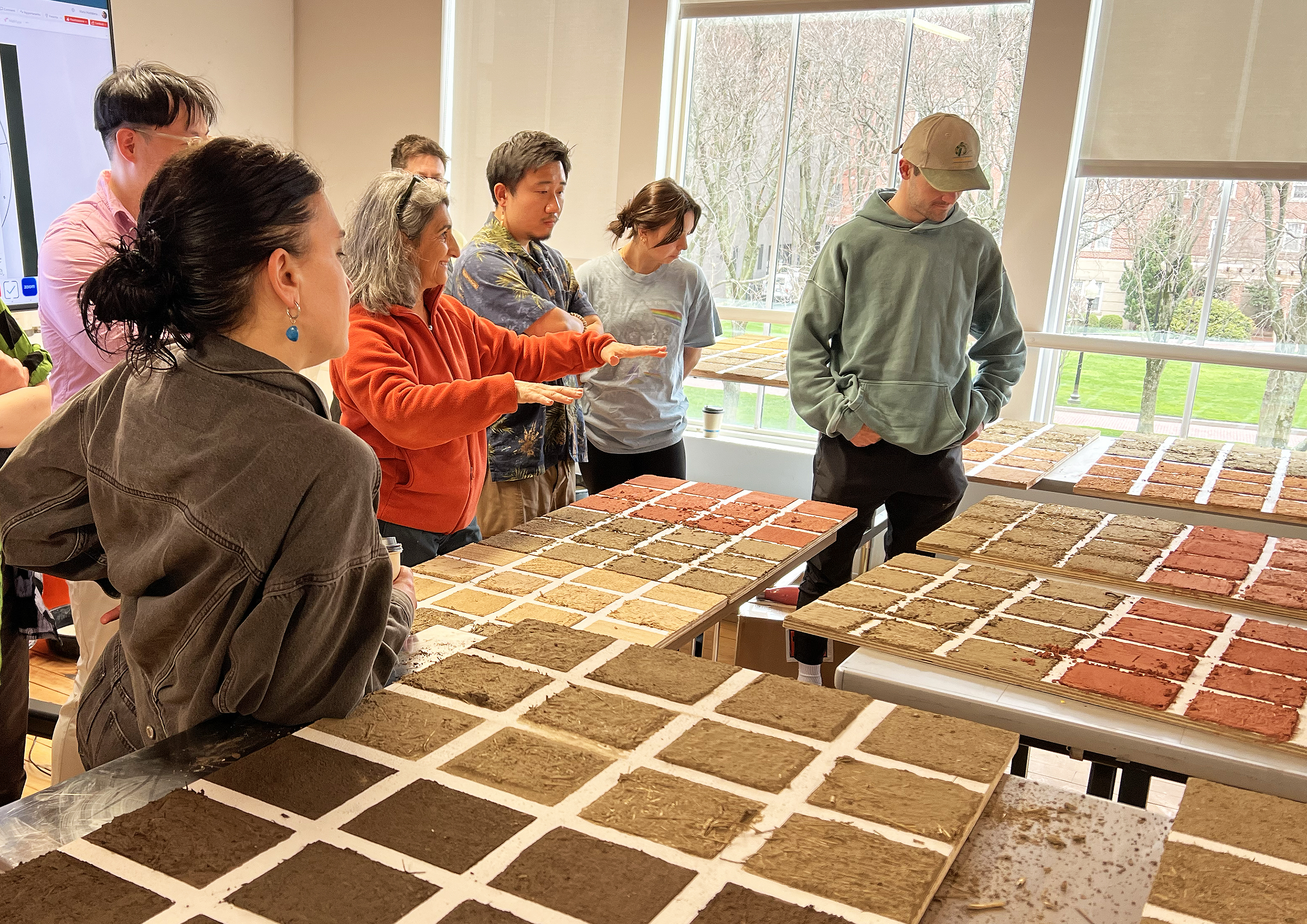 Achenza and students discuss brick samples on the tables