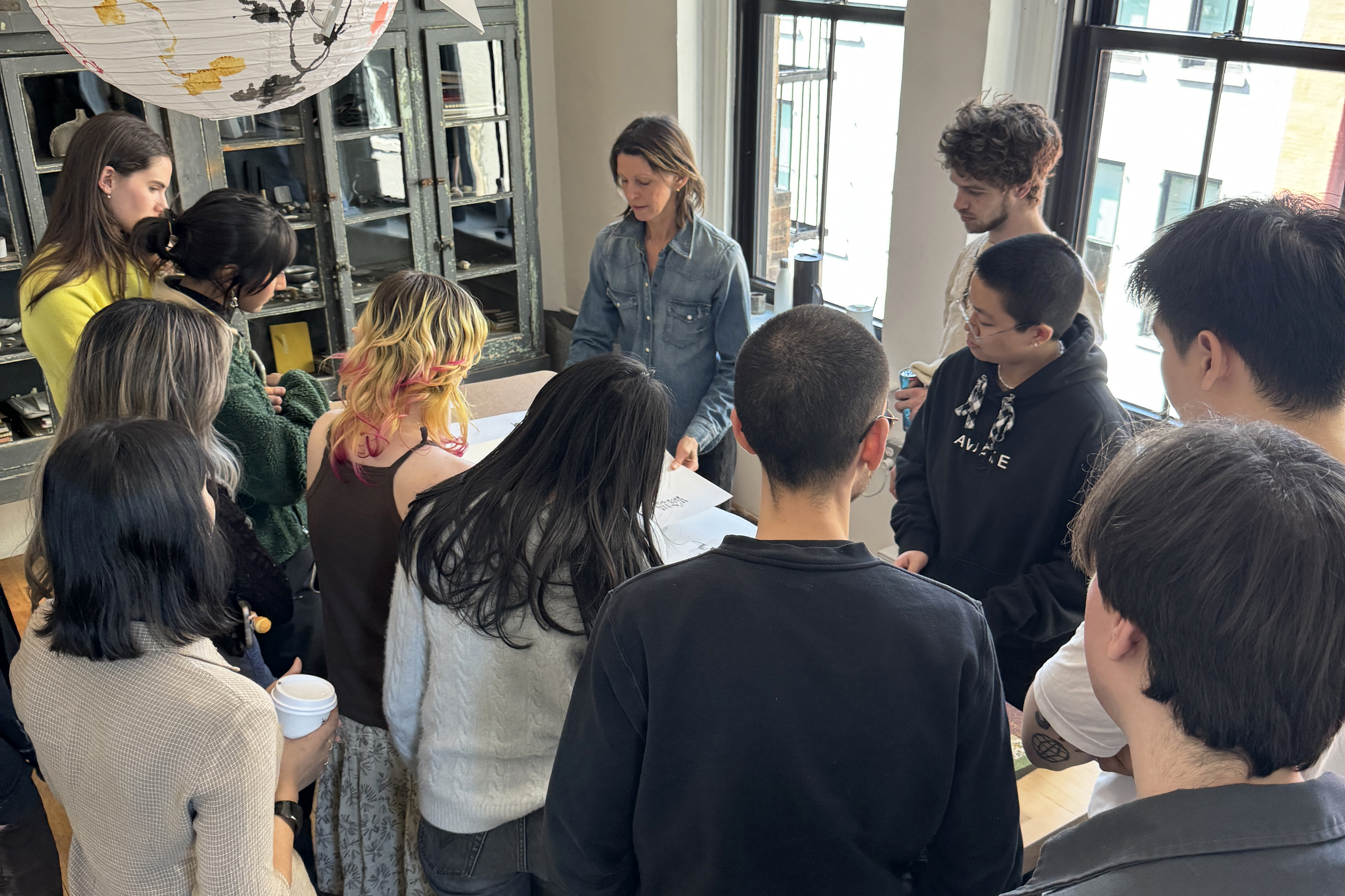 students gather around alum lighting designer Lindsey Adelman