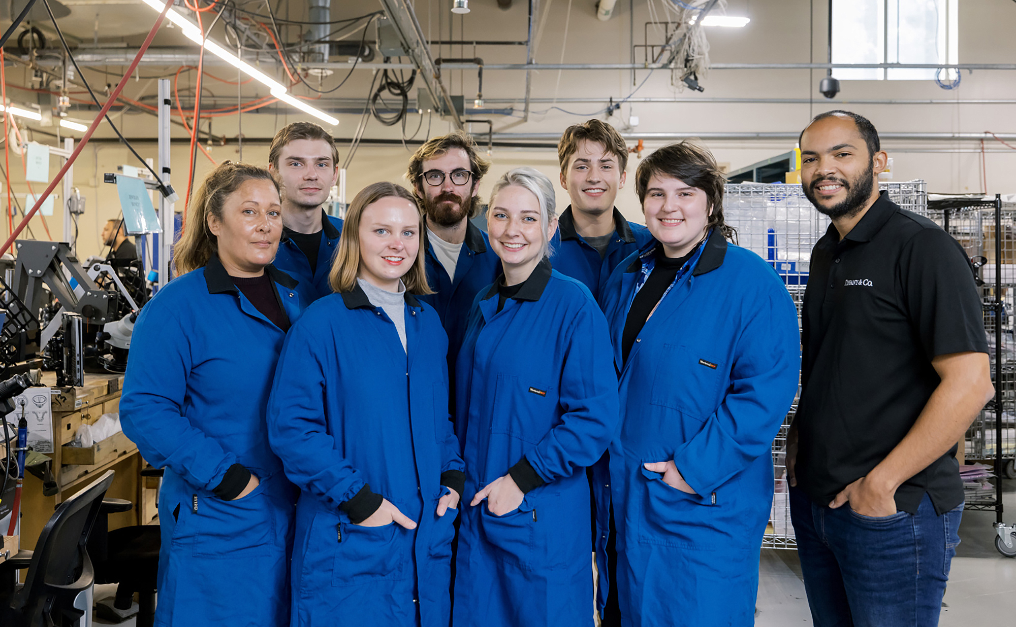 the full cohort at Tiffany facility wearing matching blue jumpsuits