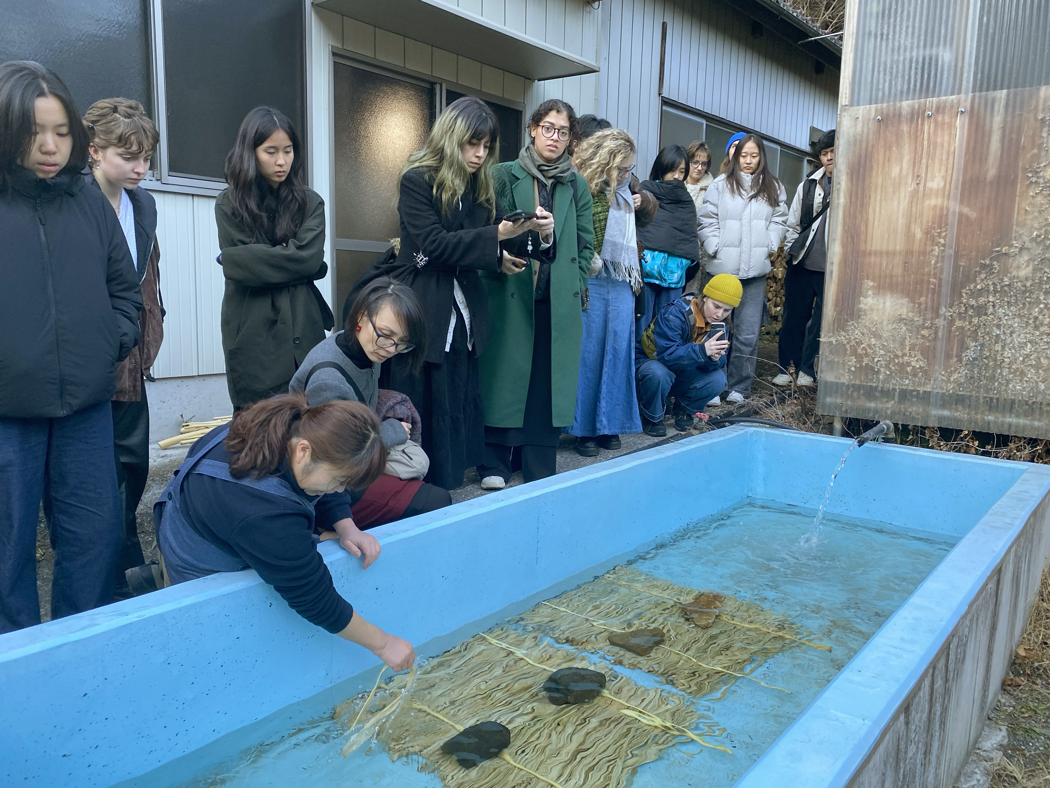 students observe traditional paper-making techniques in a rural studio