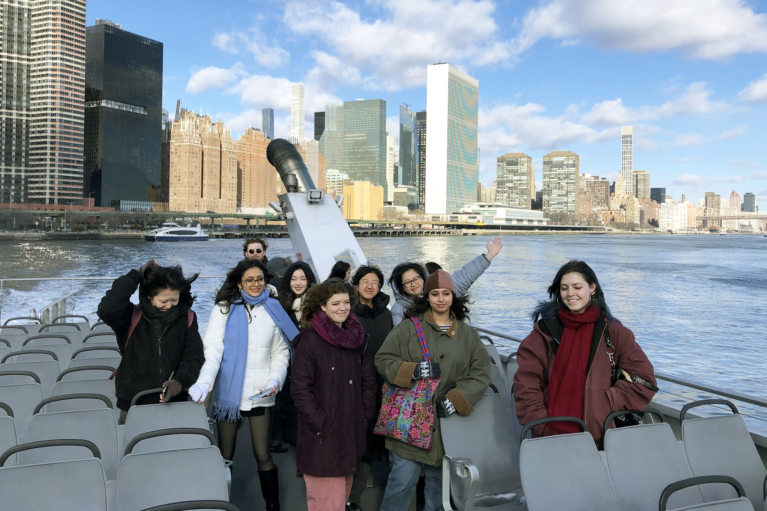 students pose for a photo on the ferry to Brooklyn on a cold winter day