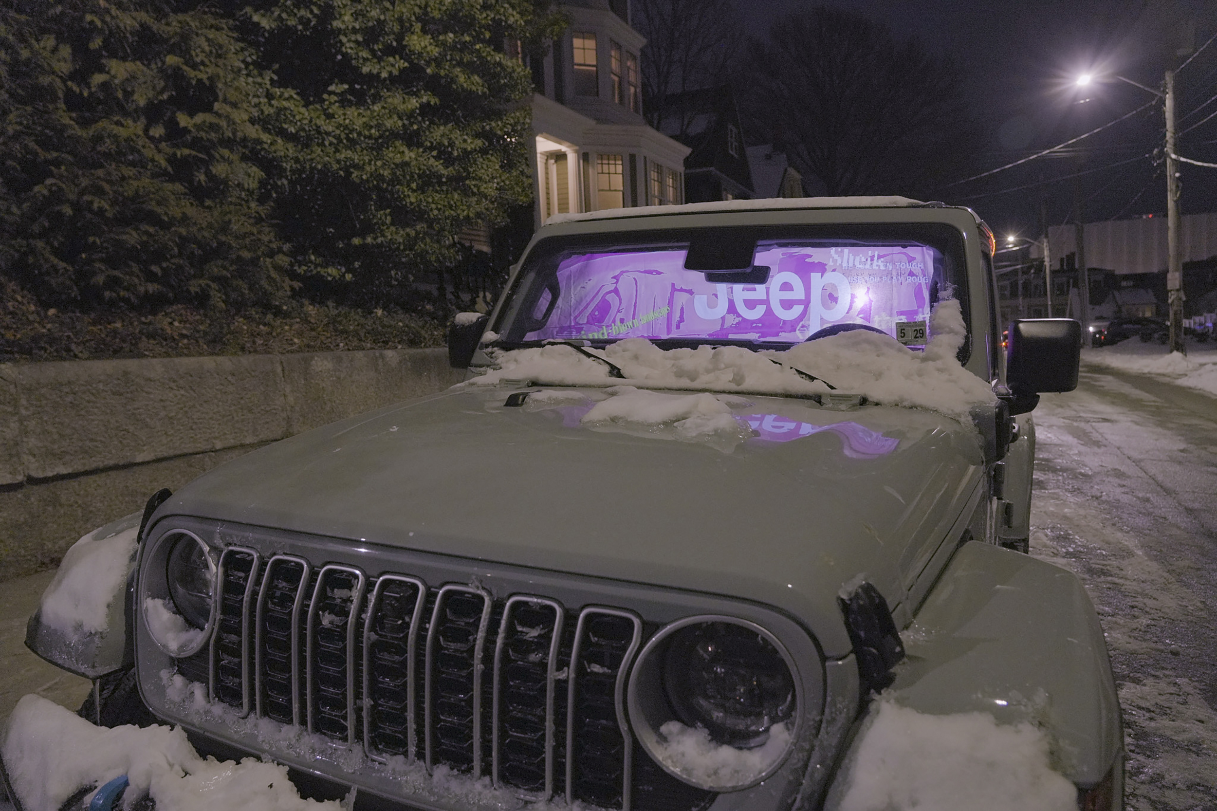 a jeep parked in the snow with a jeep-related projection in the windshield