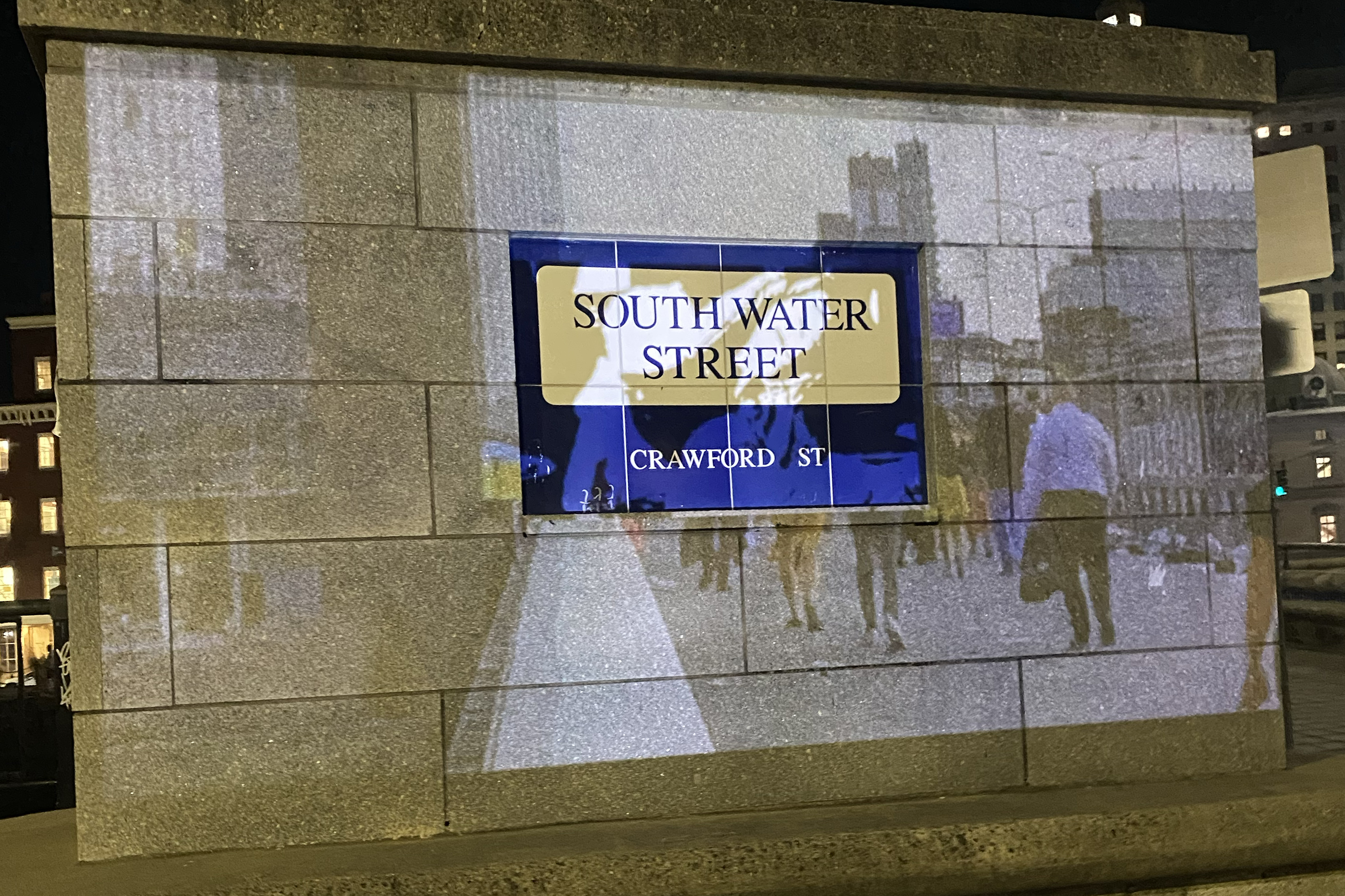a projection over a concrete wall with embedded street sign