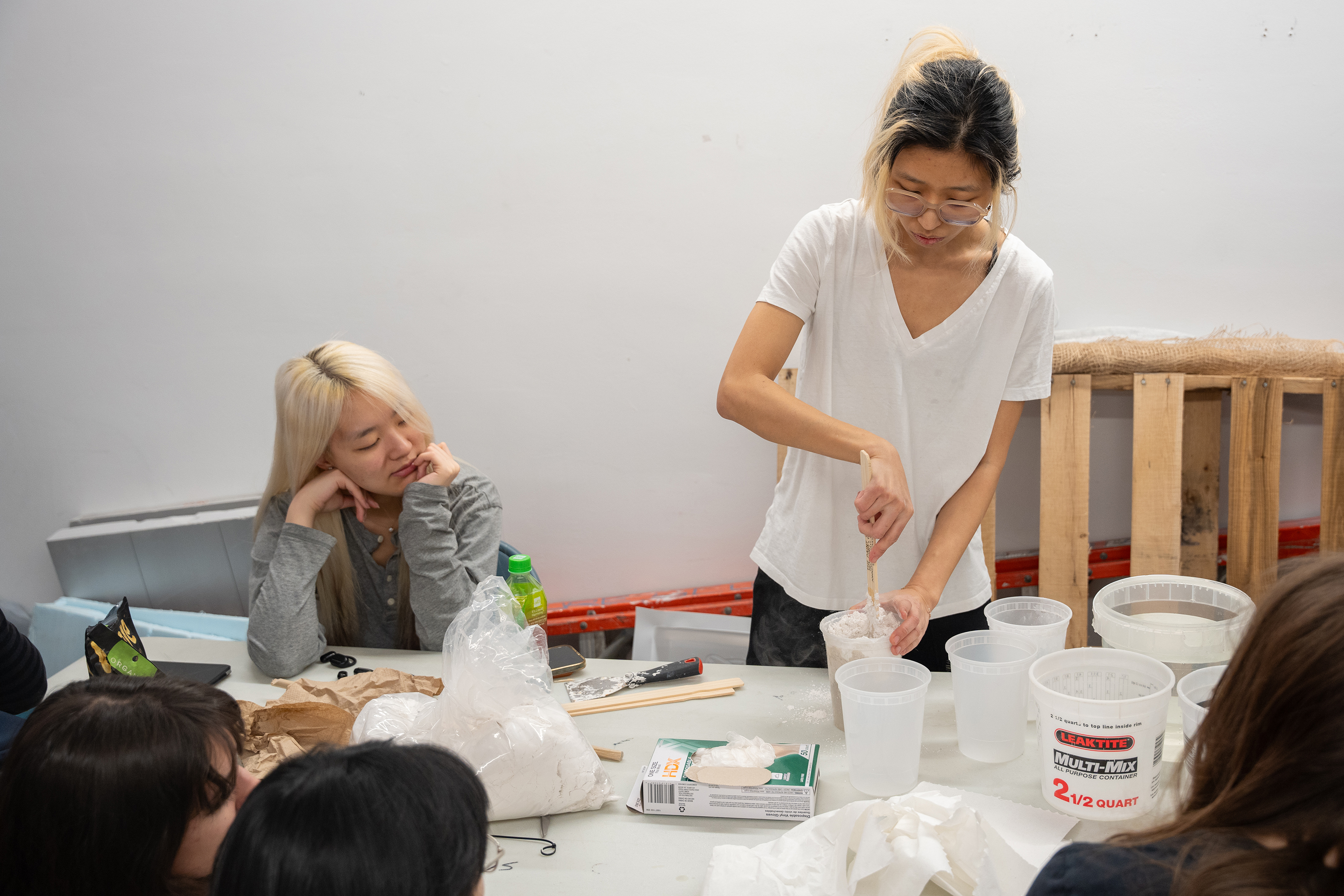 Jaimie An mixes mold powder as the class looks on