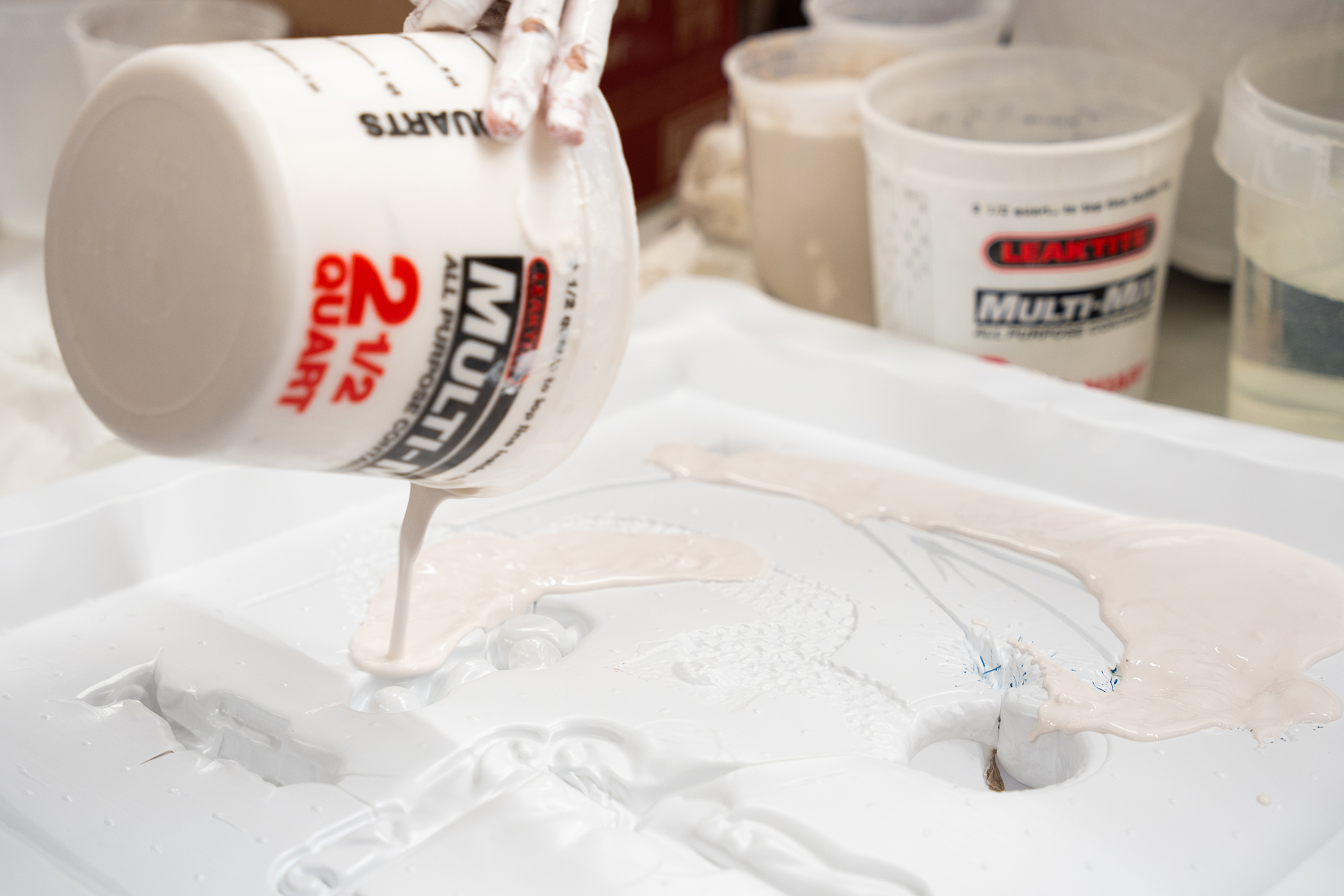 she pours the liquid plaster into a prepared mold