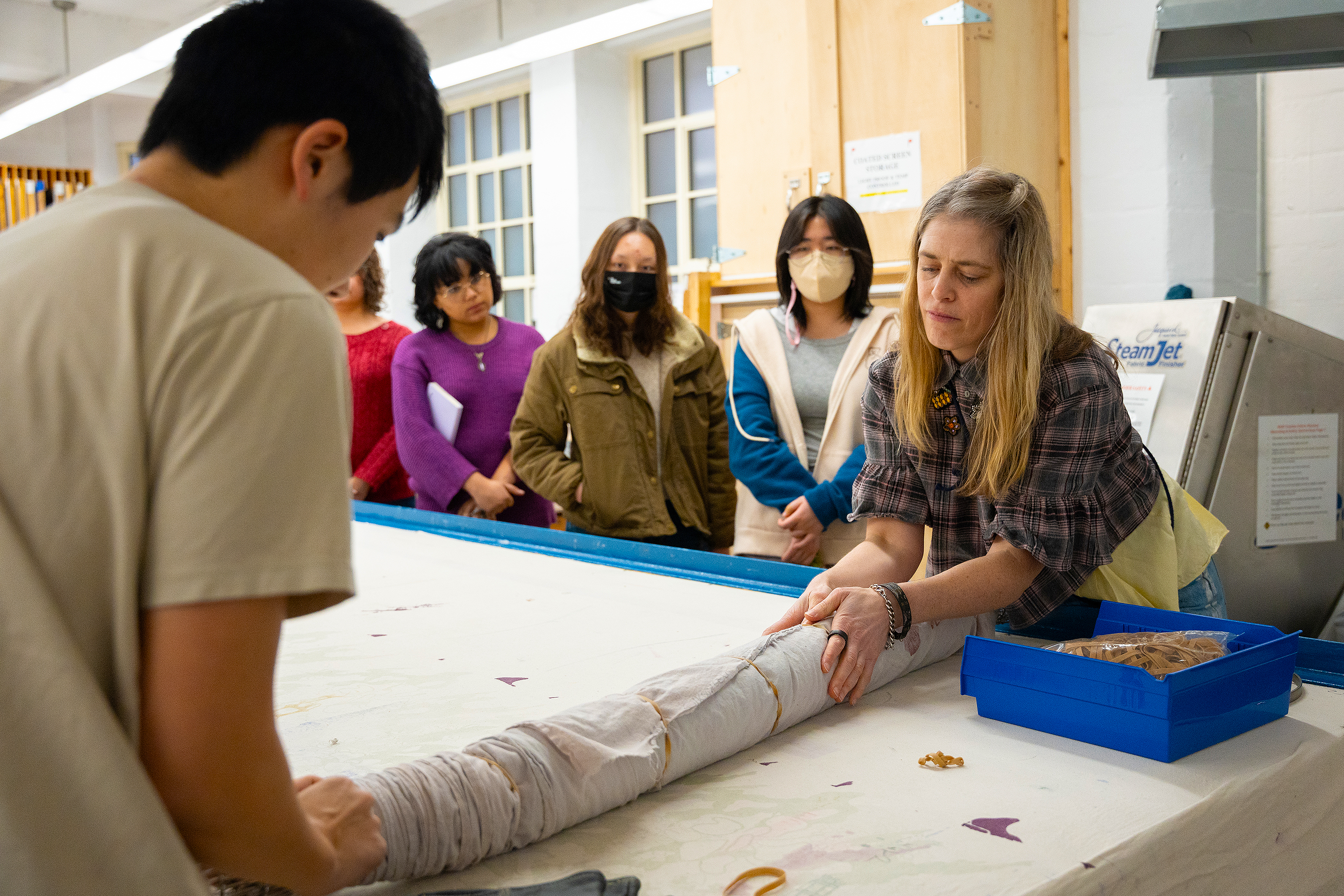 April Chambers rolls up the fabric before putting it in RISD's industrial steamer