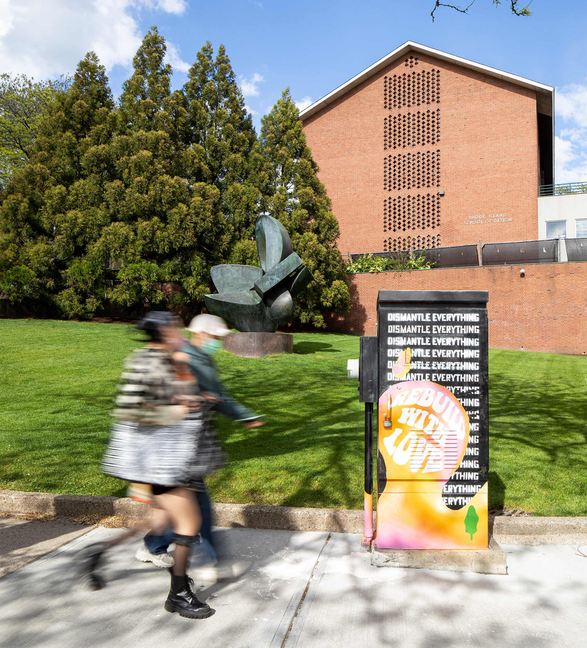 students walk past "RISD beach" on a fine spring day