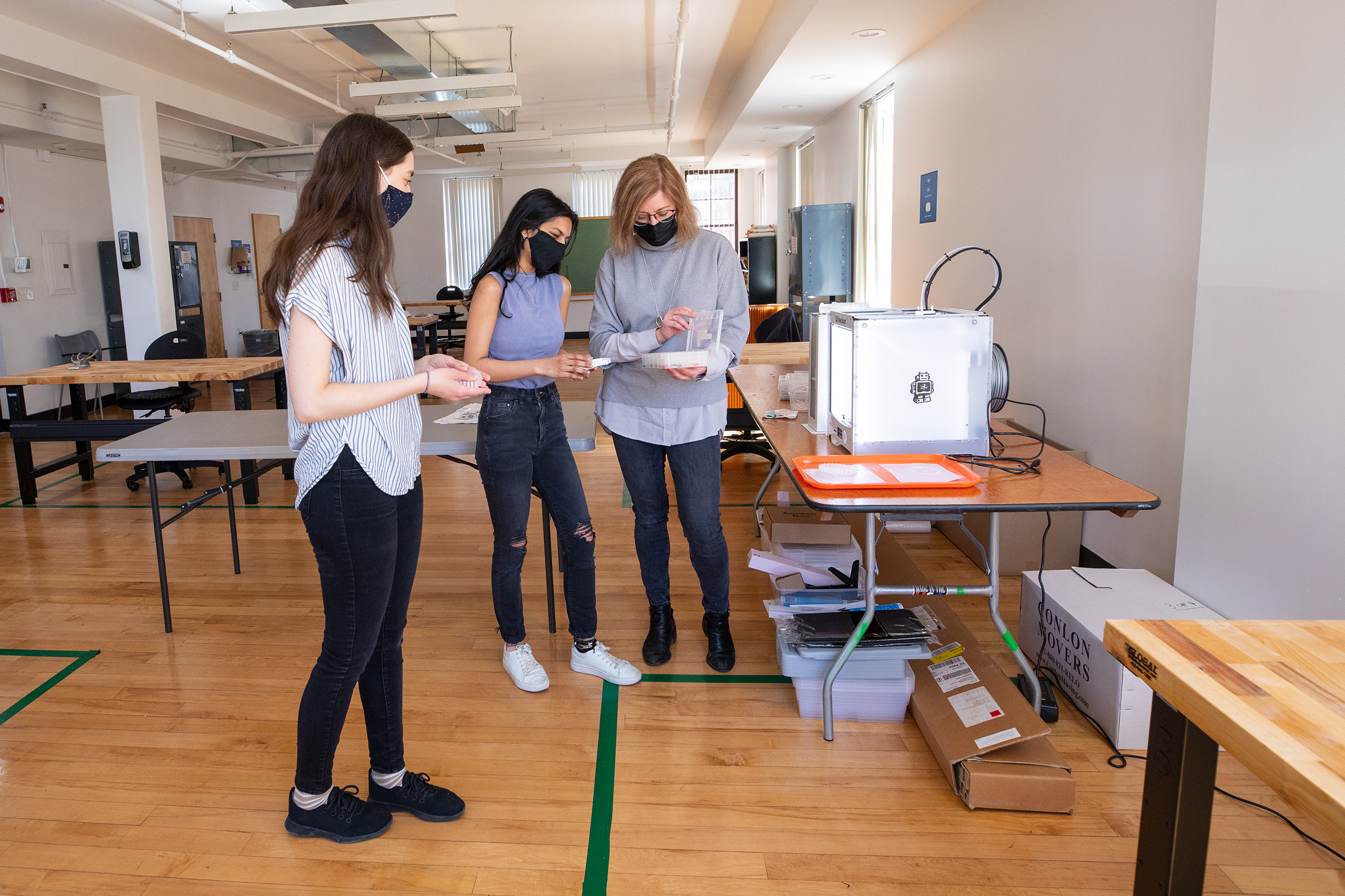 faculty member and students work together with 3D printer