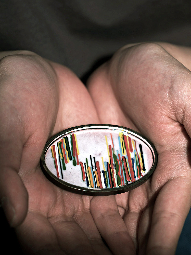 hands holding an oval artifact by Tony Kwon