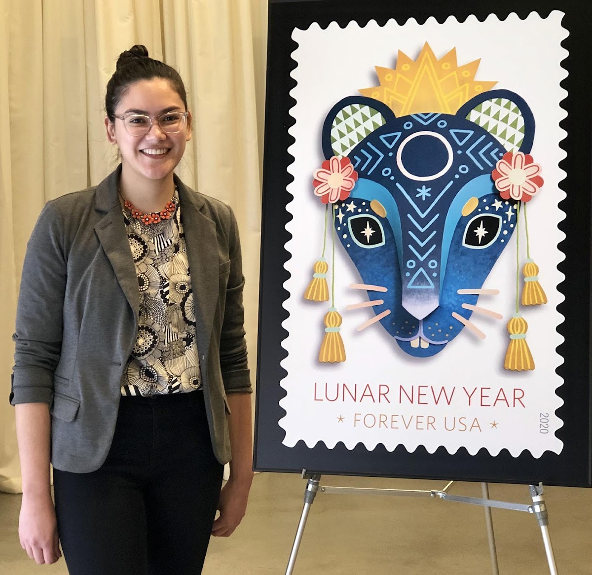 Camille Chew MFA 20 PR with poster of stamp commissioned by the US Postal Service