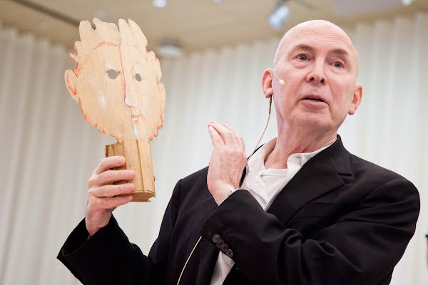 Design advocate and curator Murray Moss holding up a wooden face