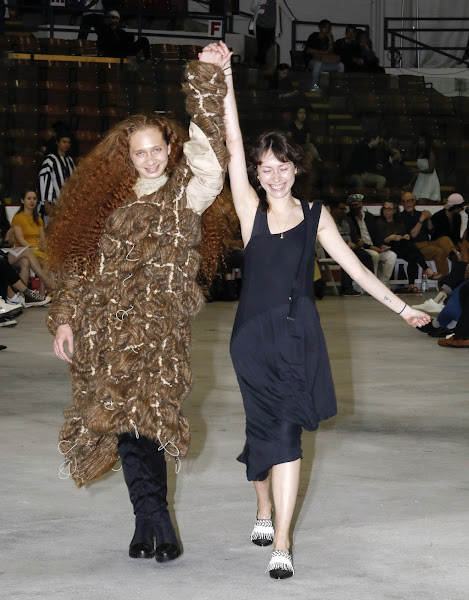 Masha Kurguzkina 19 AP takes a celebratory walk down the runway with one of her models