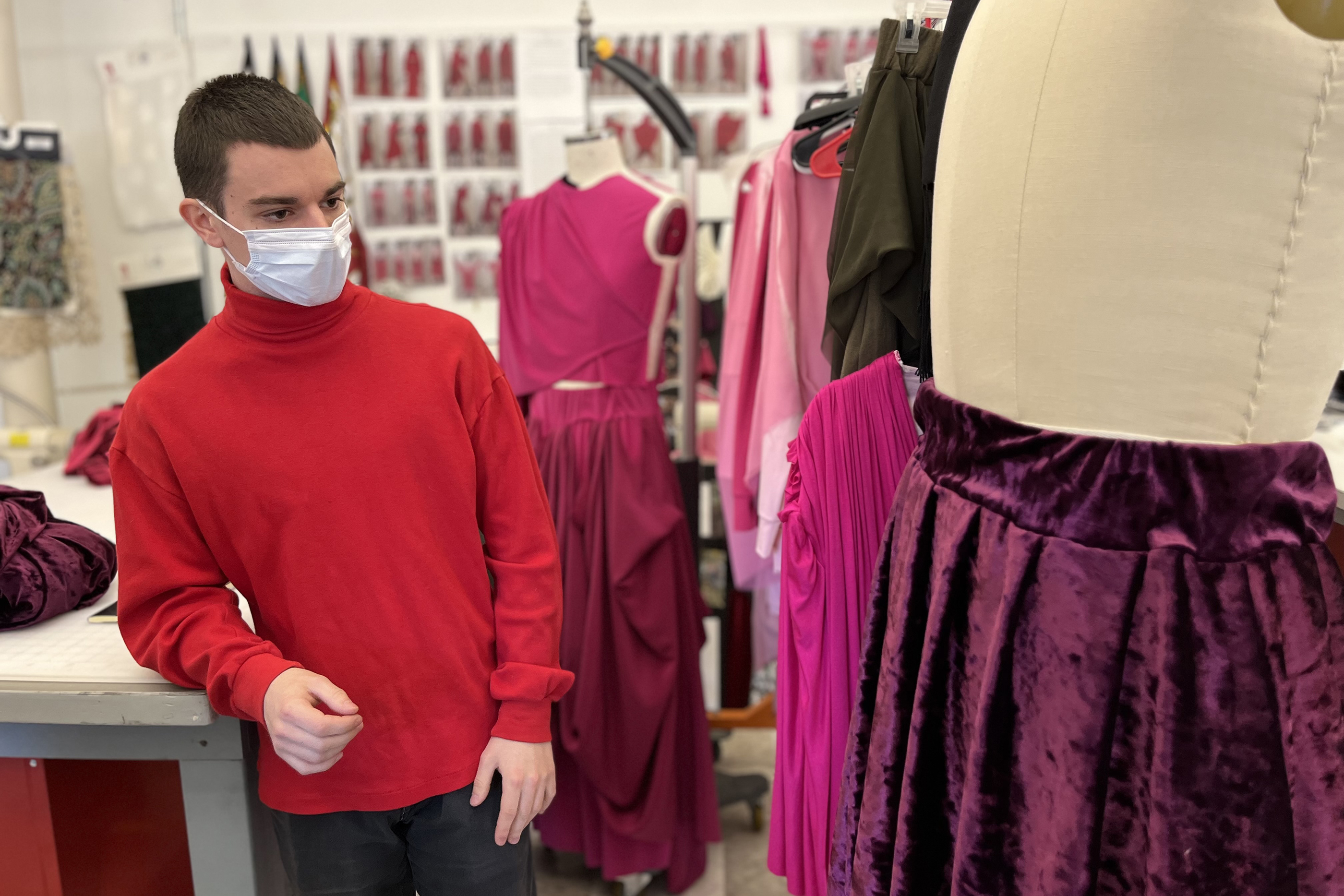 a student pauses from working on a mostly pink collection