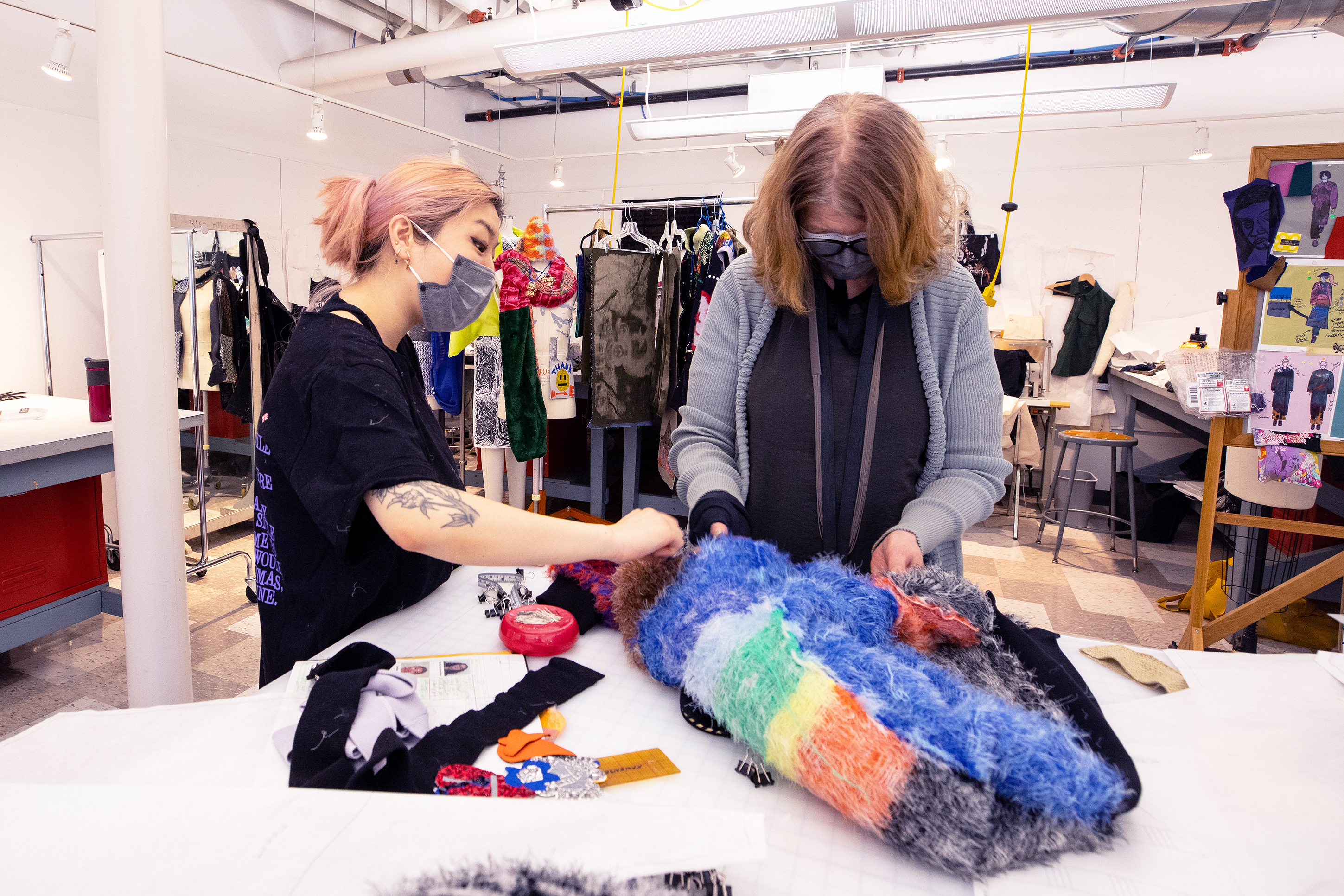 a student and faculty member examine a piece in progress