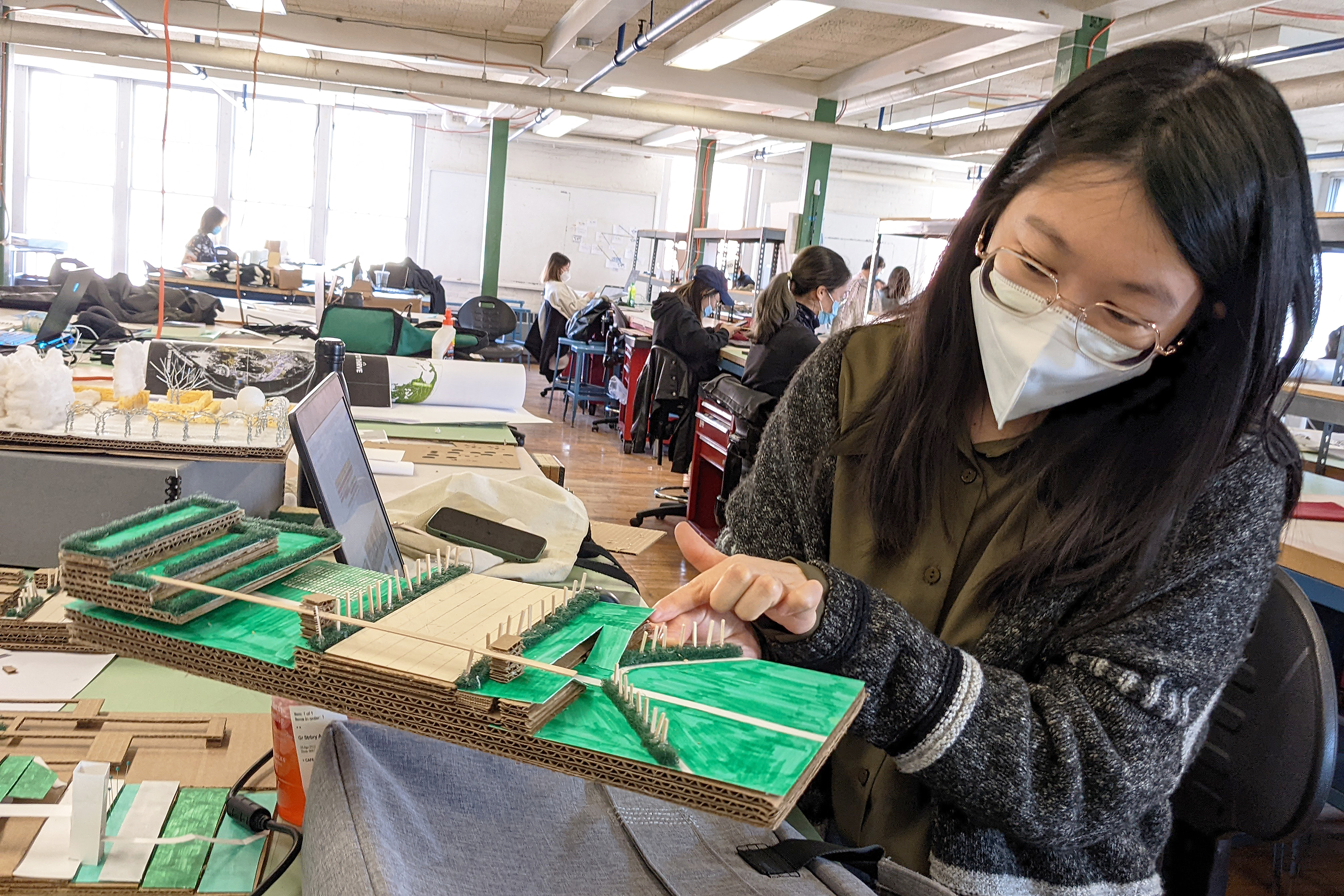 a student presents a cardboard model of the landscape